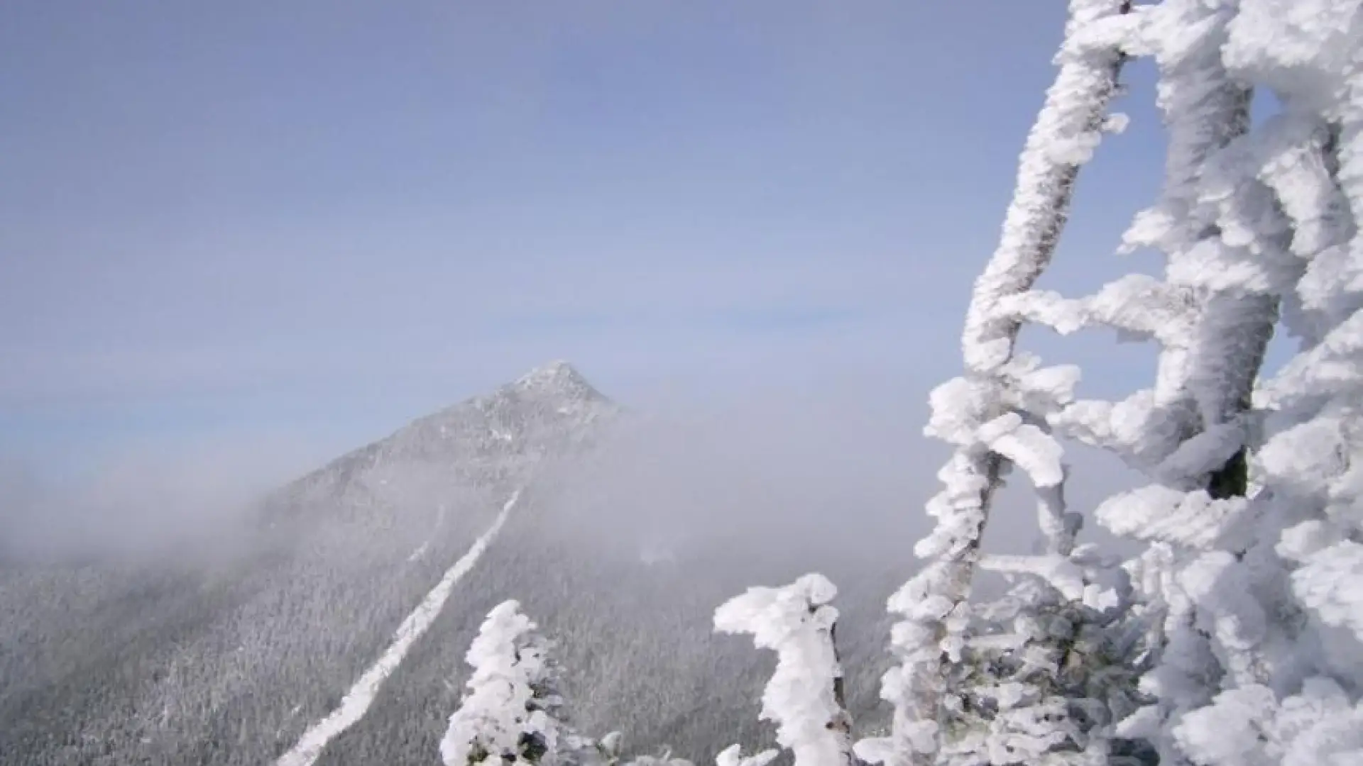 A winter view of a high mountain with a rock slide on it