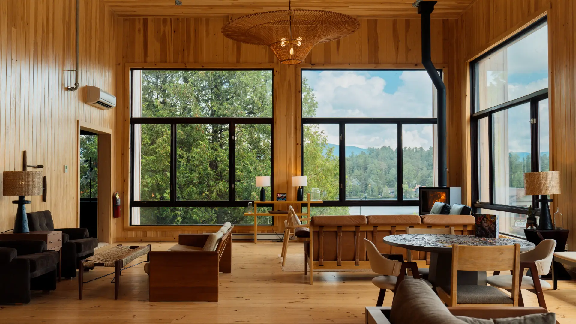 The fully wooden double height lobby with grand windows overlooking Mirror Lake with ample warm leather seating and fireplace