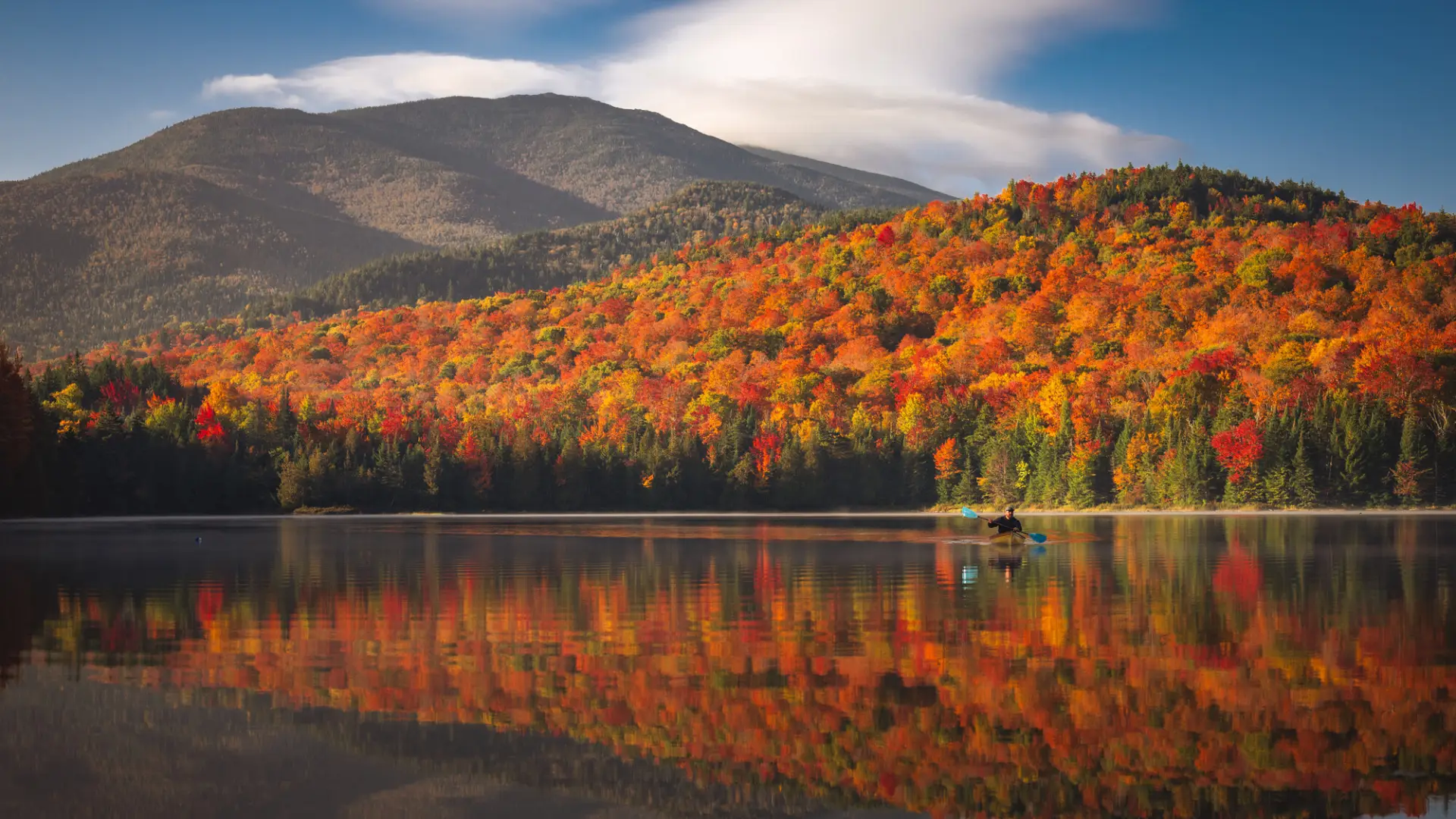 View of Heart Lake with fall foliage on mountains along shore and reflection in water