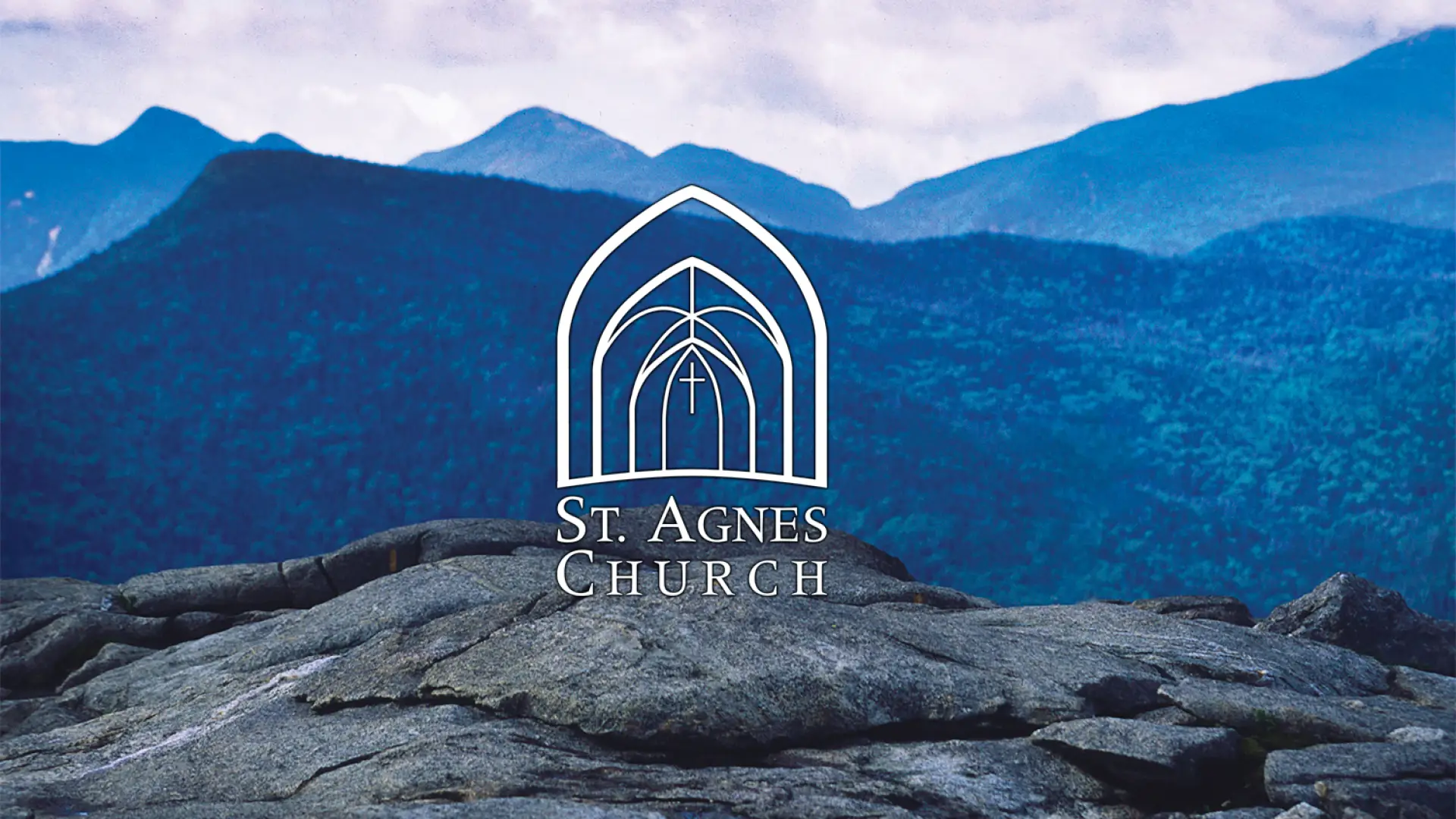 The crest of a mountain top with the blue mountains in the distance with an overlay of St. Agnes Church 
