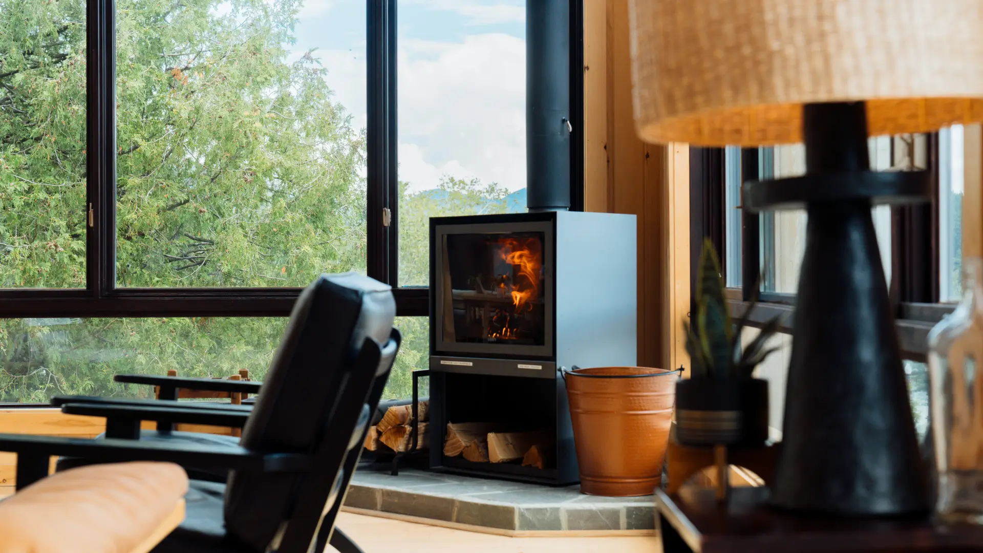 A roaring fire place in the great room with the large windows facing Mirror Lake.