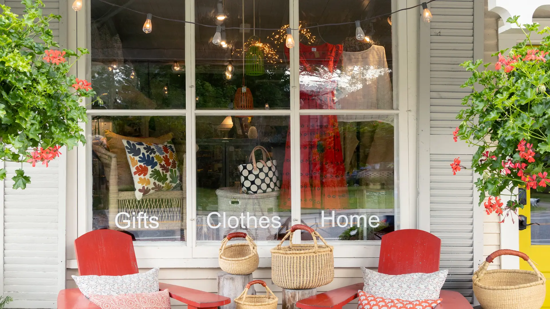 The exterior of The Birch Store with red adirondack style chairs with matching pillows