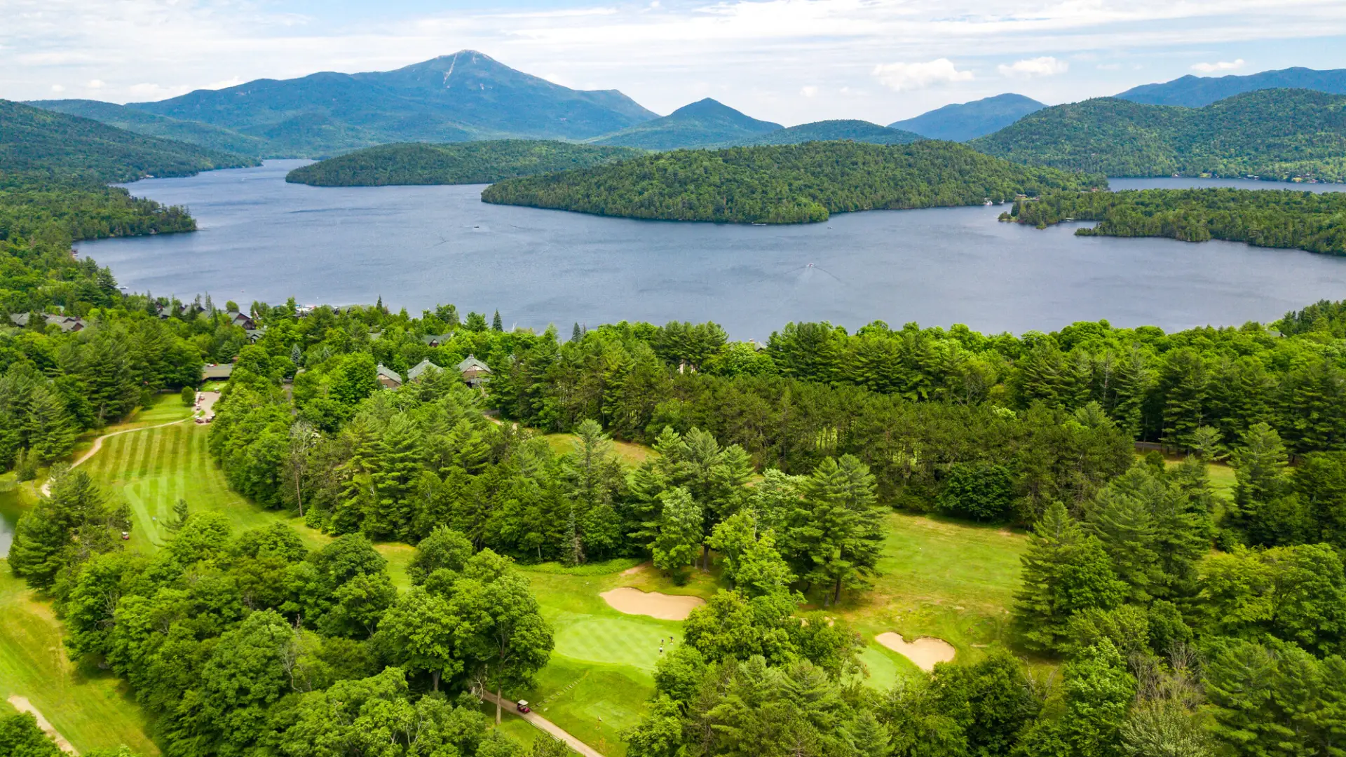 Aerial view of a large lake with a golf course beside it