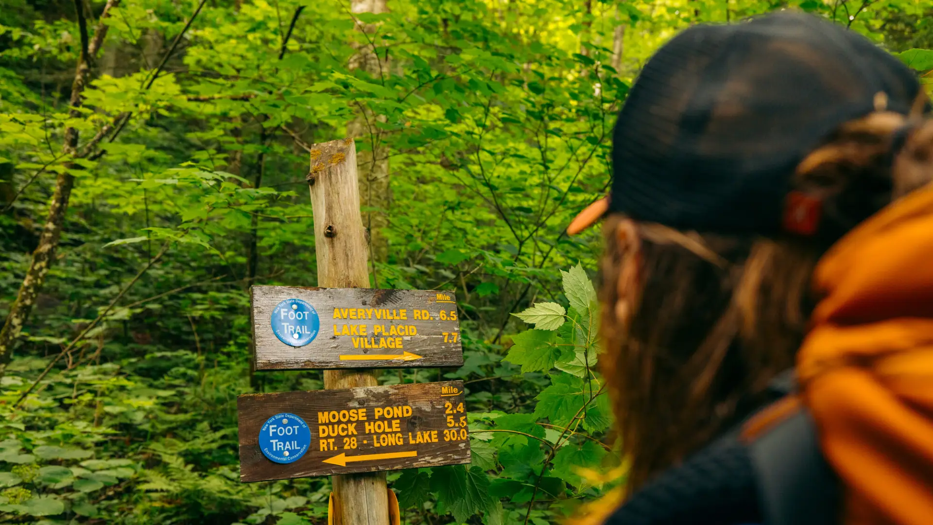 a man looks at a trail marker
