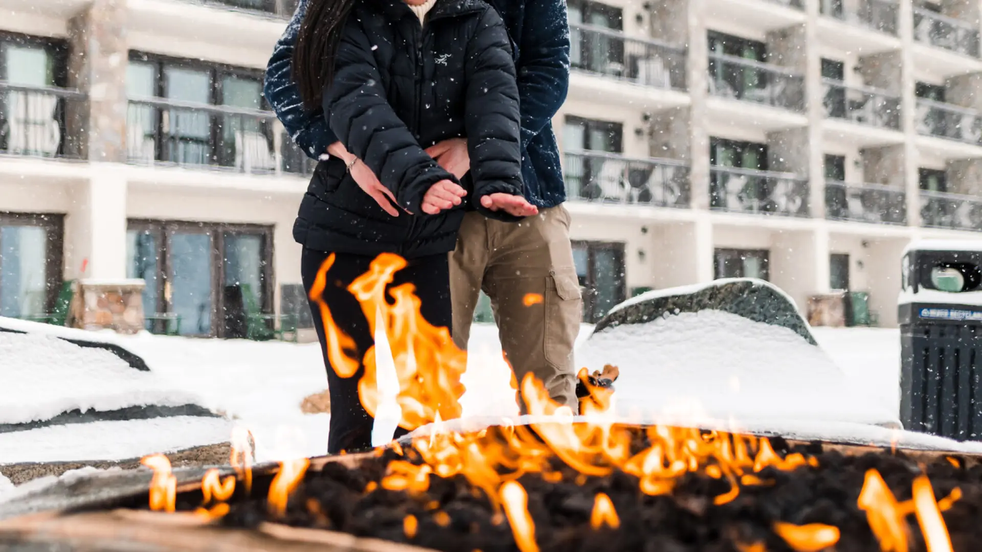 a couple gets cozy by a campfire.