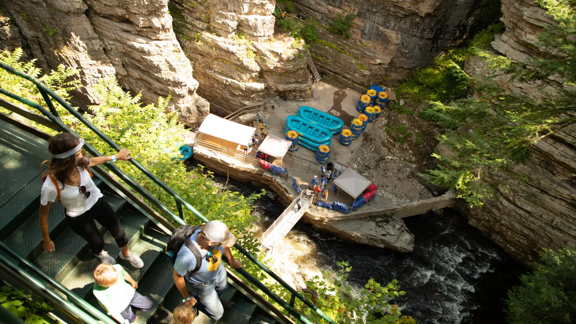 A family walking down the stairs to the landing area for rafting at Ausable Chasm.