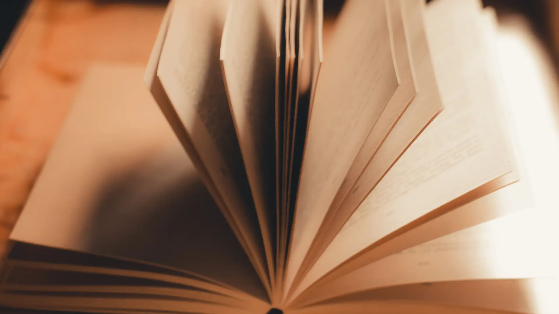 Stock image of open book on table with pages turning