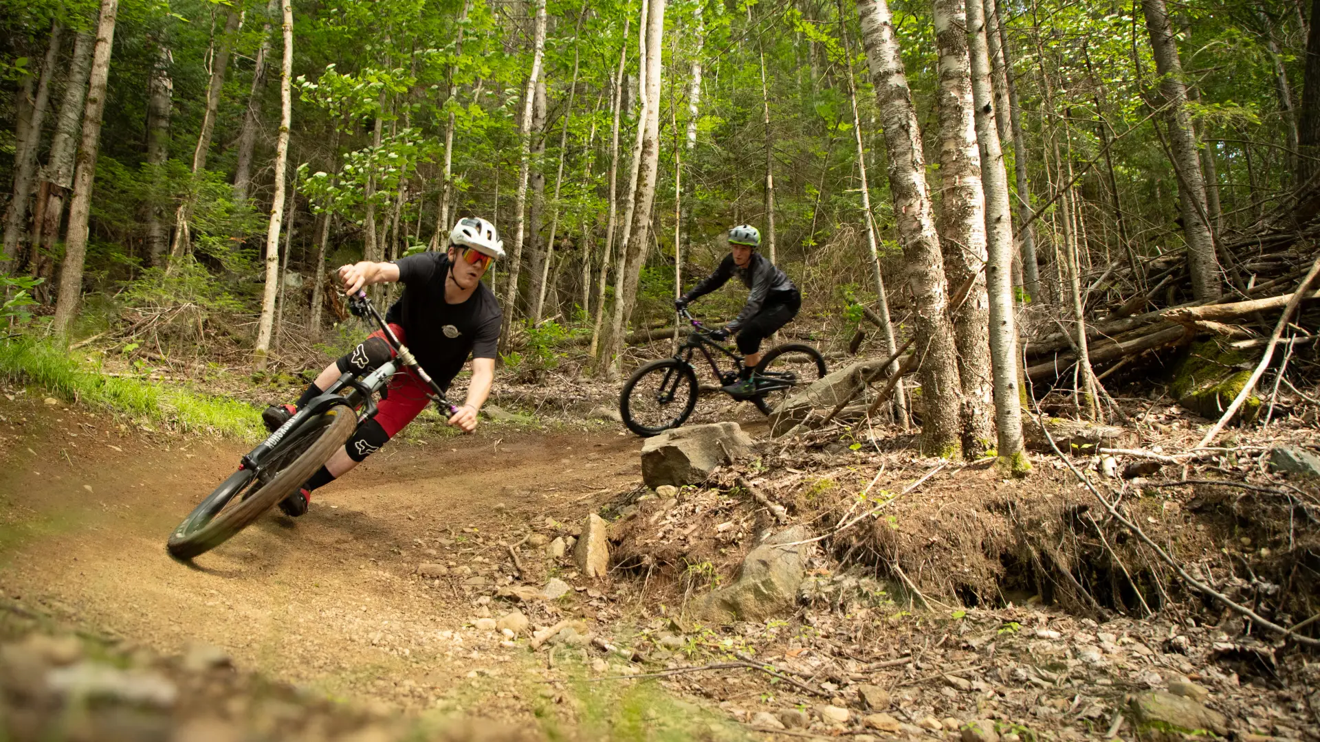 Two riders coming around a corner on one of Lake Placid's epic mountain bike trails
