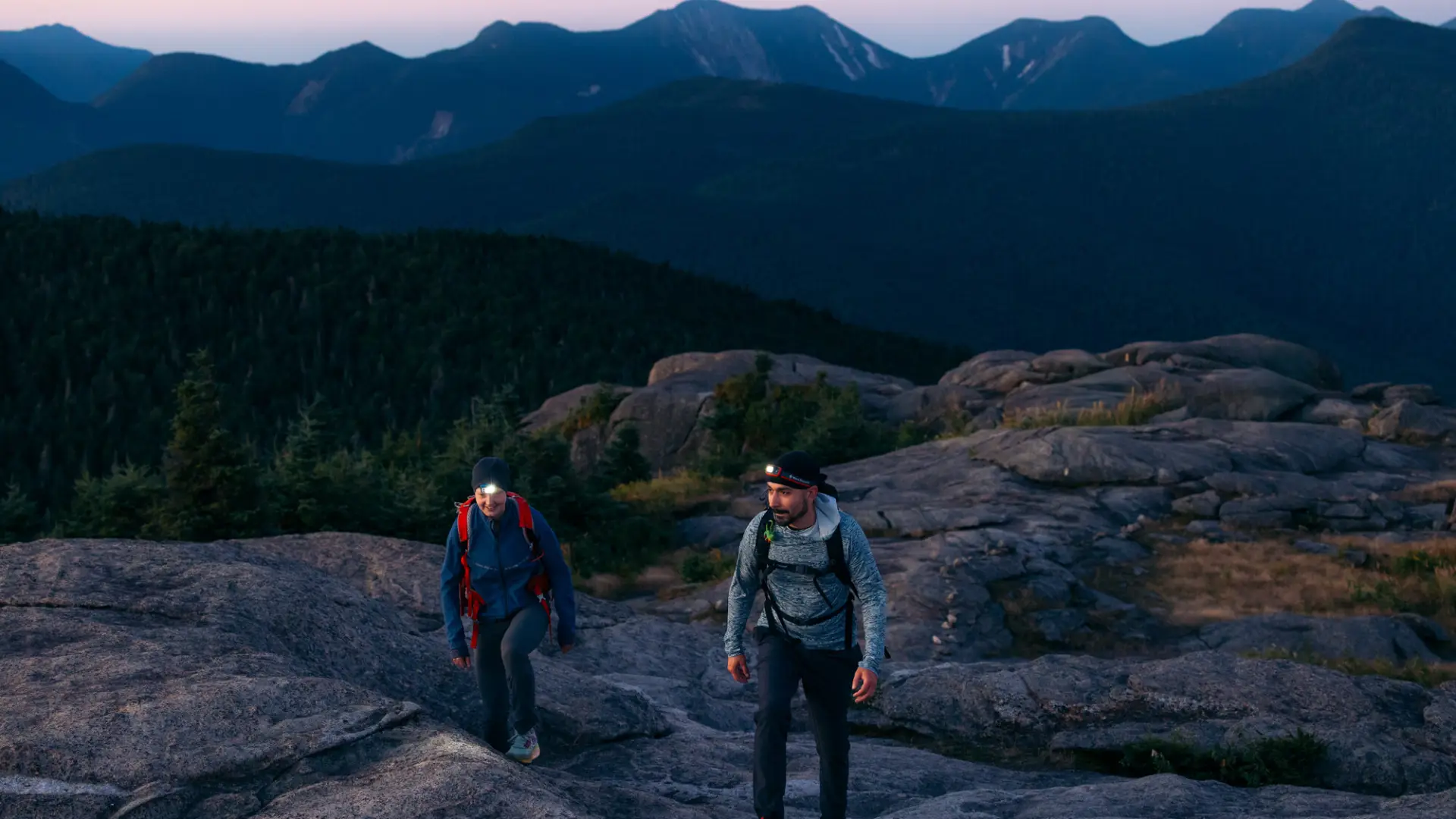 Two people hiking up a rocky ridge