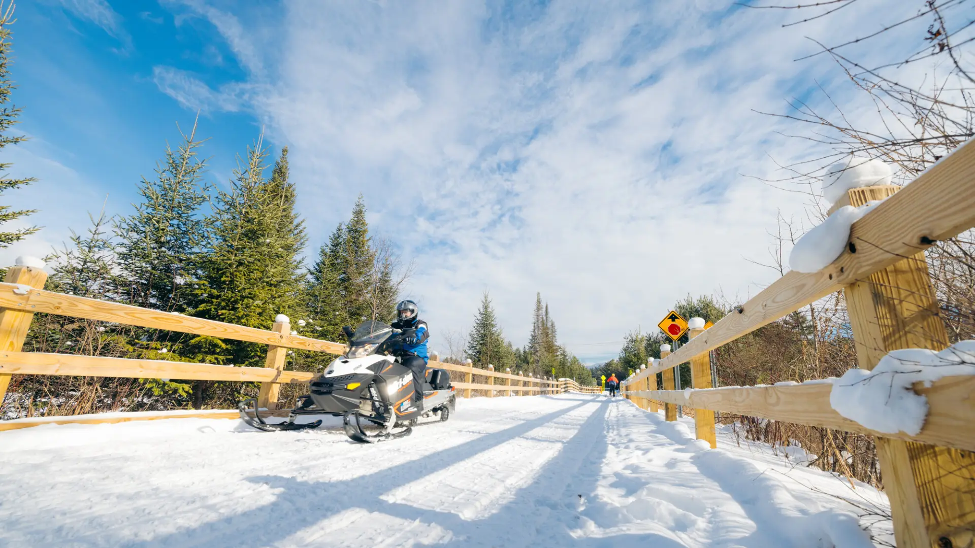 A snowmobiler and a skier on the Rail Trail.