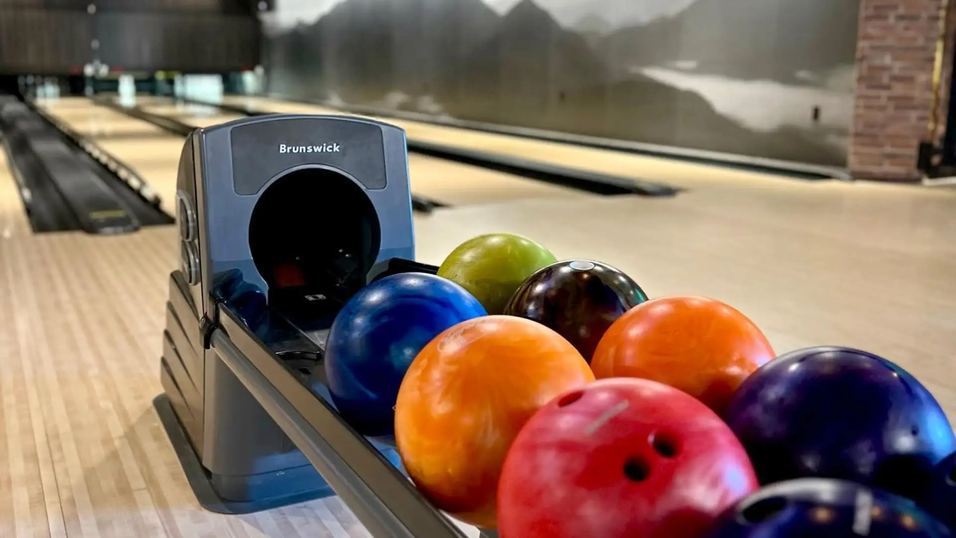 A bowling ball return full of colorful bowling balls