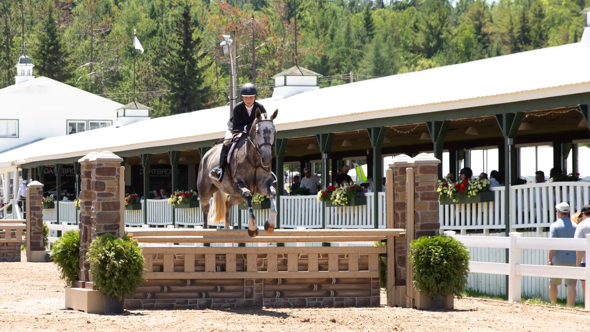 A participant riding a horse as it jumps during competition