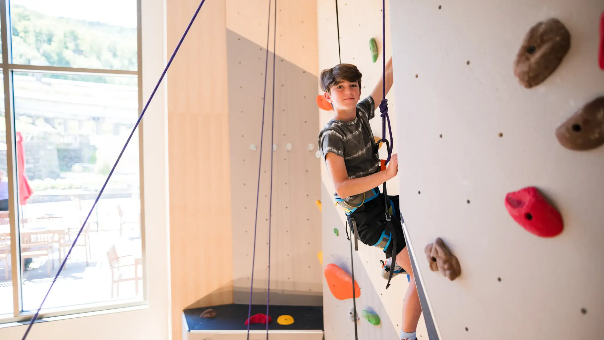 A child climbing at indoor climbing gym.