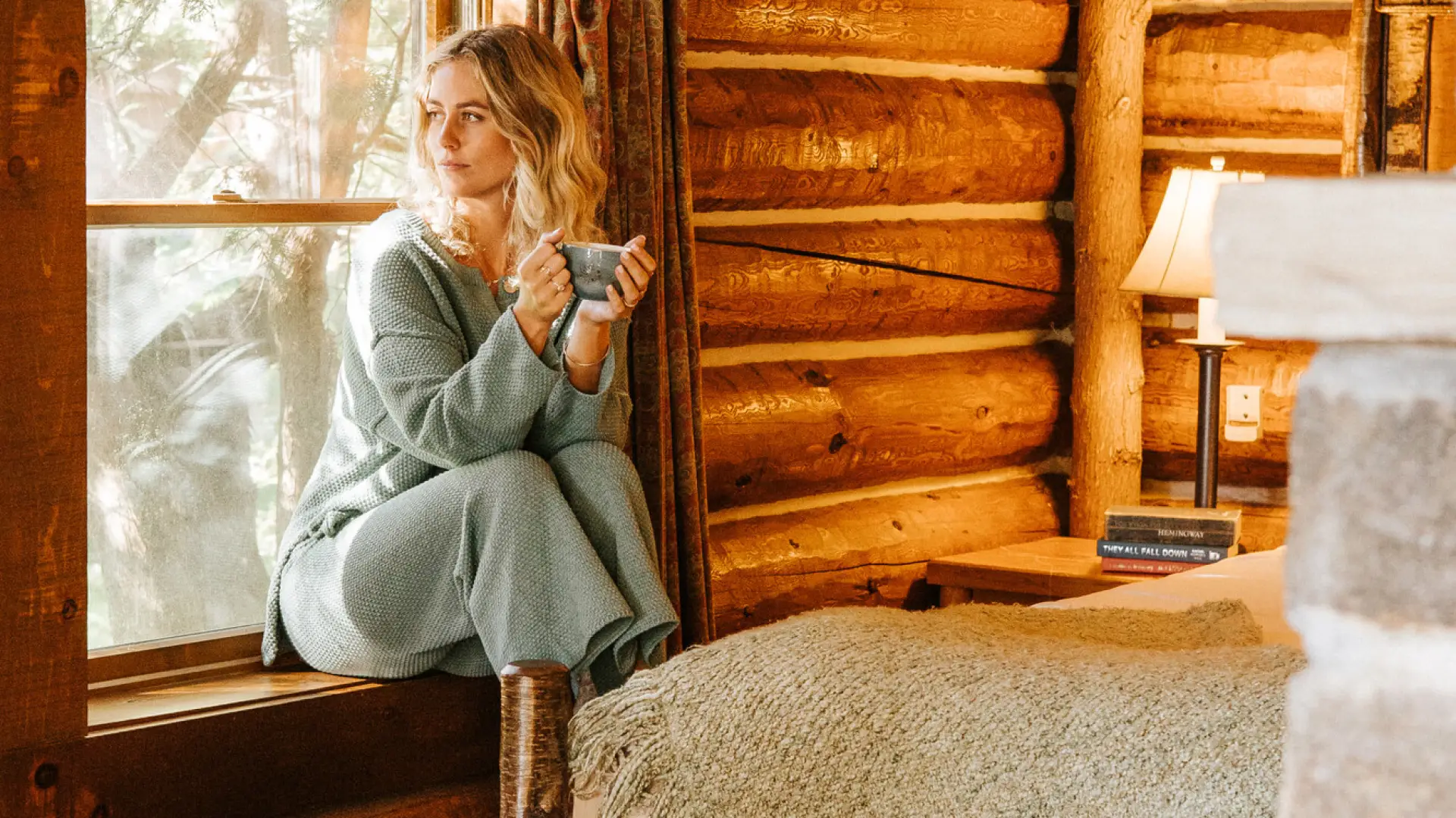 A woman sits in a cabin window.