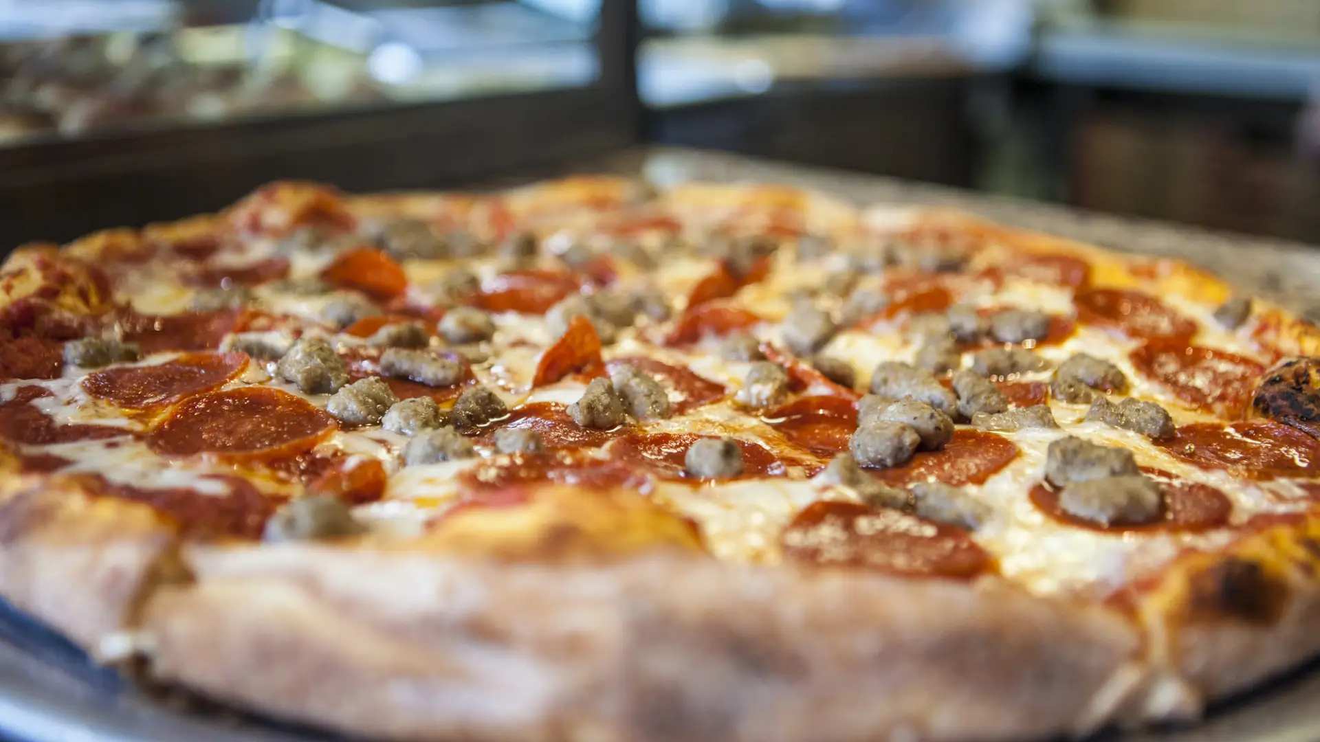 A close up of a pepperoni and sausage pizza.