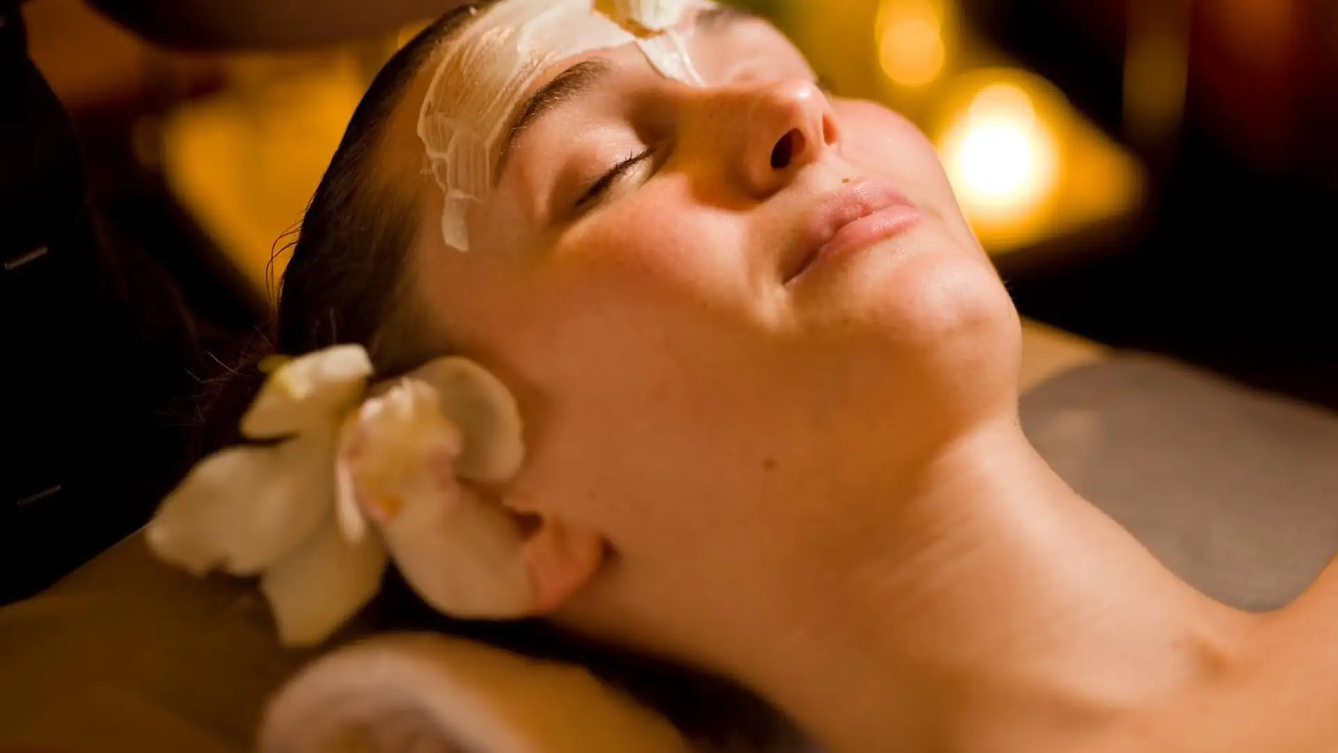A woman receives a facial mask.