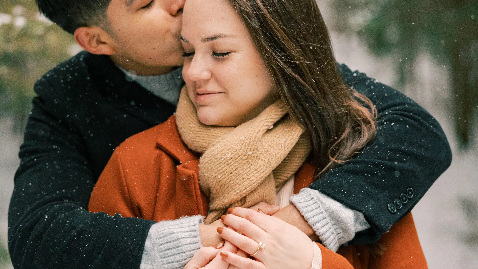 A couple embraces in the snow