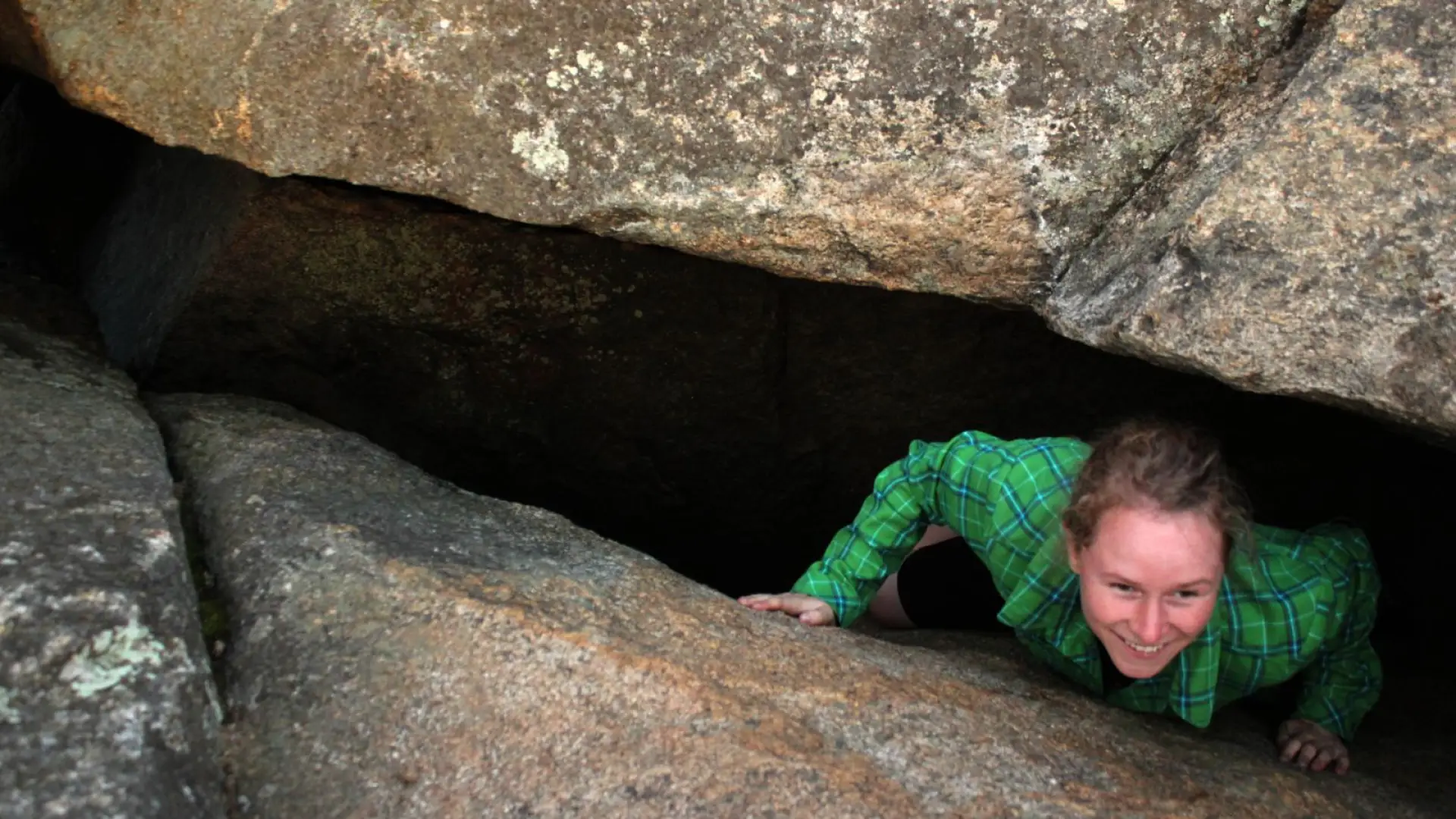 Emilee exits the cave-like crack in the ledge.