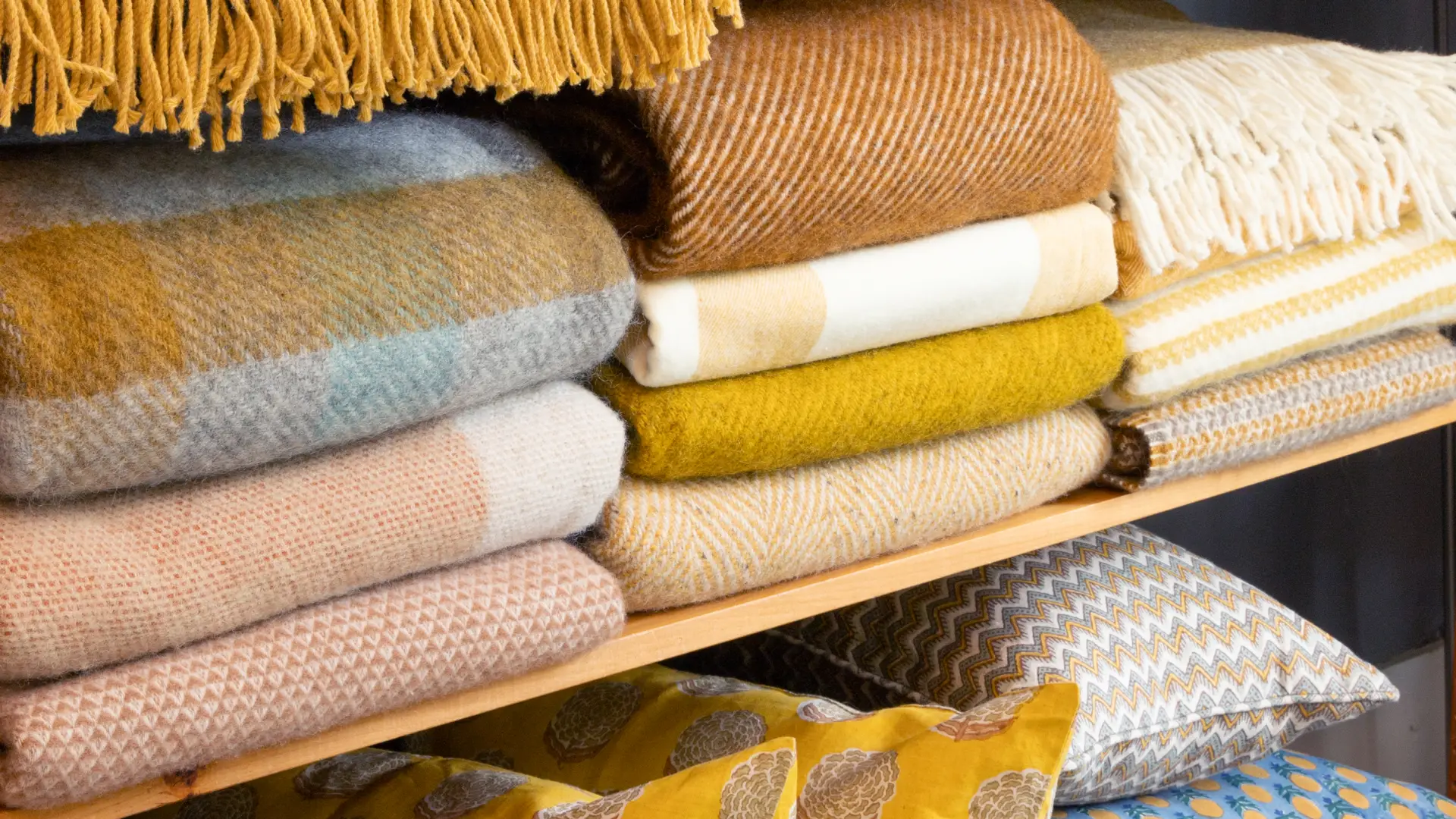 Fine wool blankets and complimentary pillows sit on a shelf