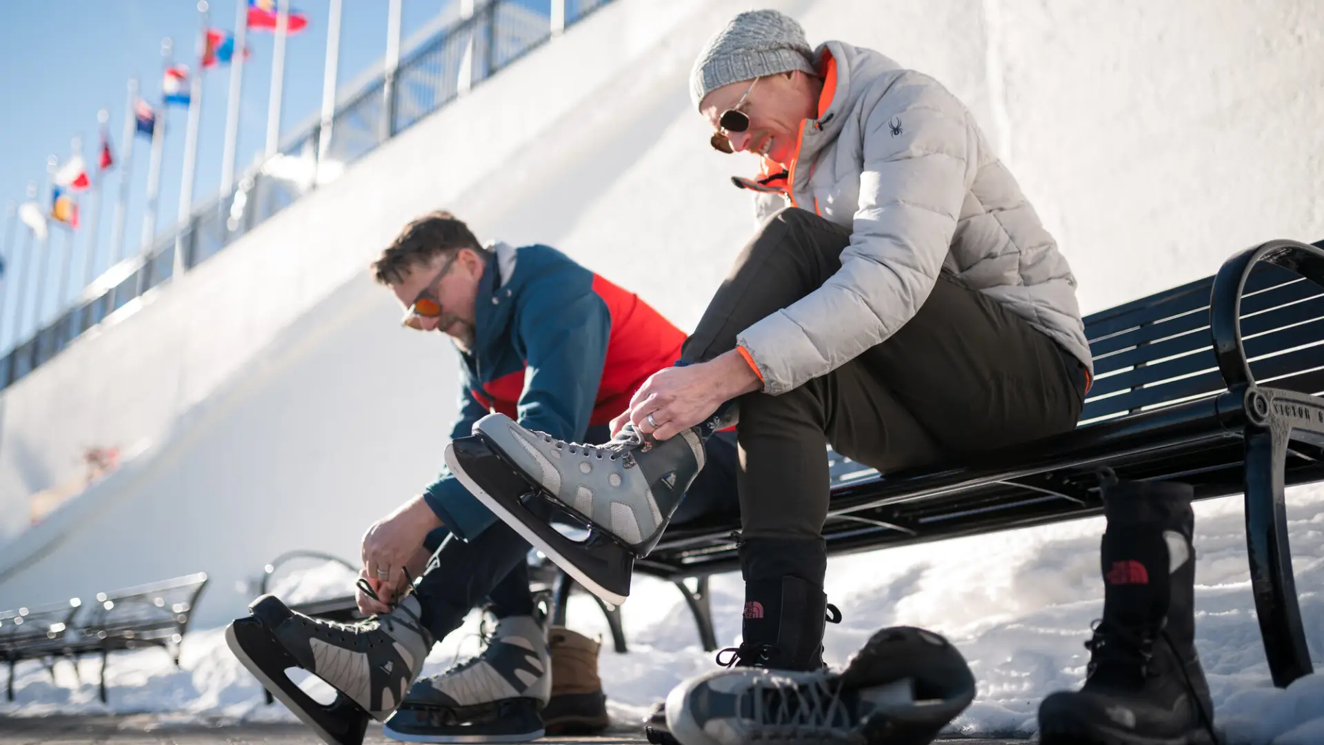 two friends lacing up skates to play outside.