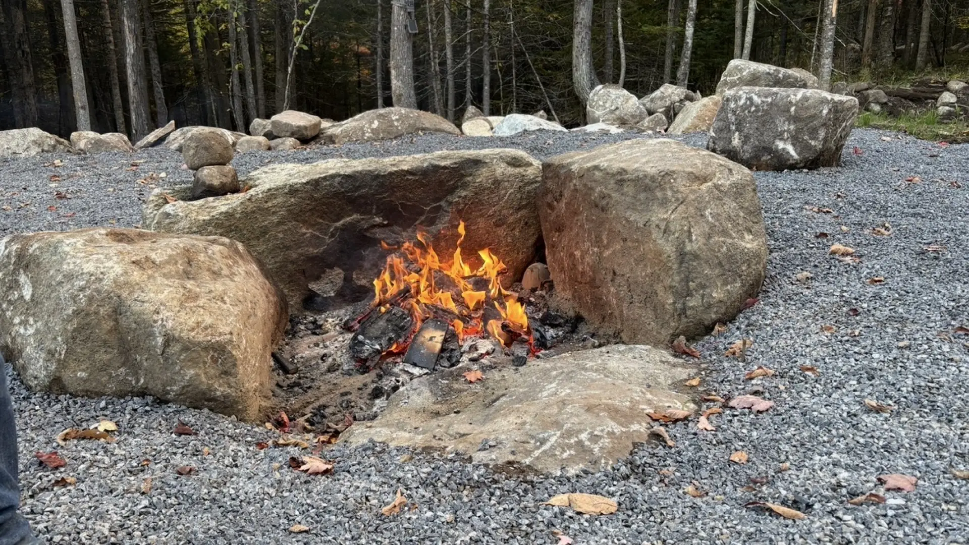 Three boulders arranged in a semi circle to contain a fire pit.