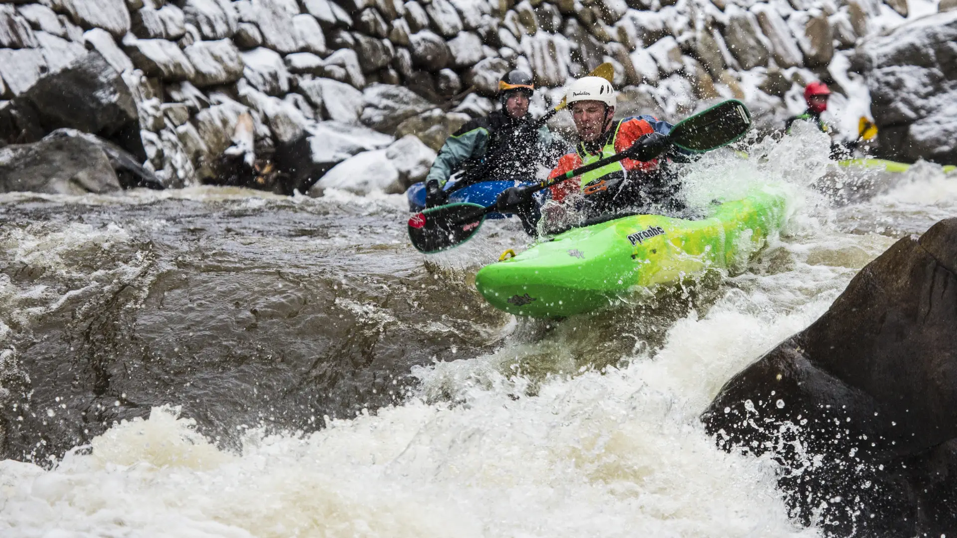Two men white water raft in rapids.
