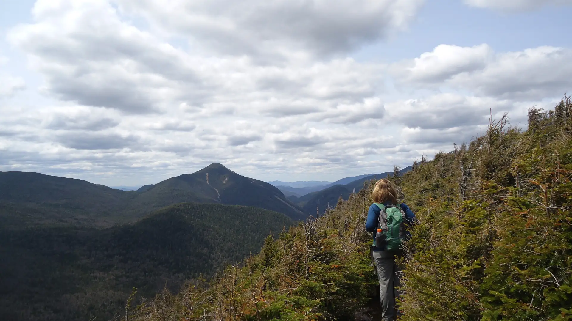 A hiker taking in the views from a summit