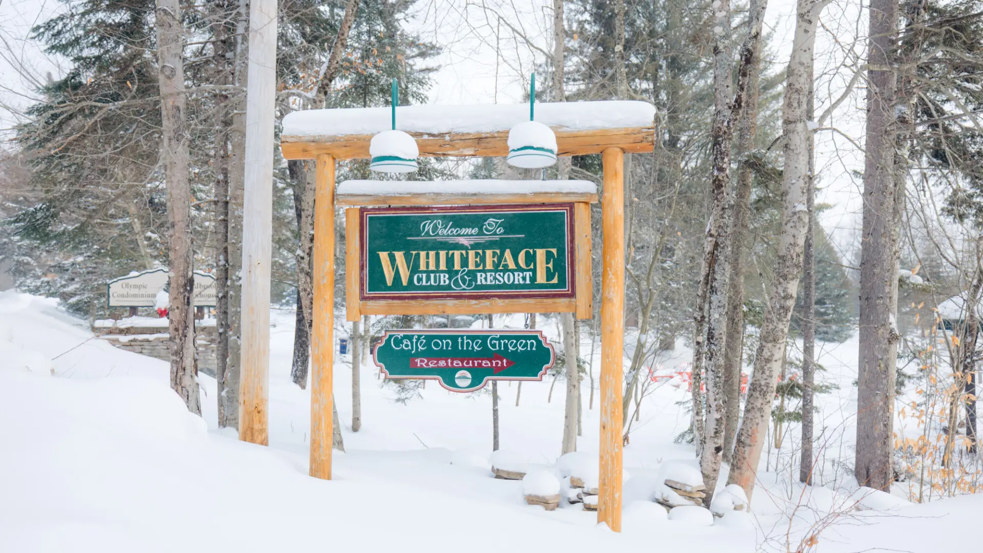 Roadside sign for Whiteface Club & Resort covered in snow