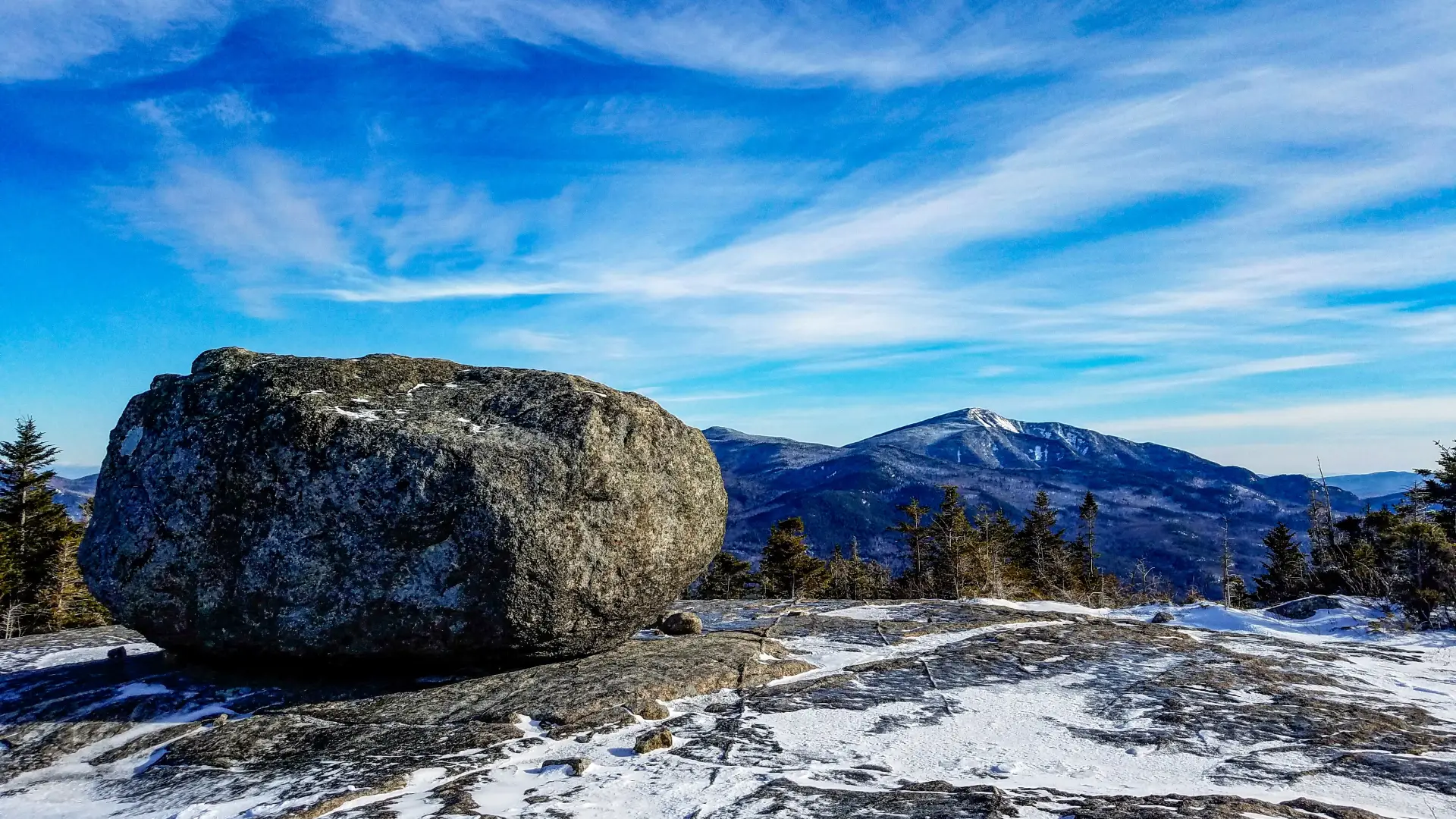 A large boulder on a wintry mountain summit