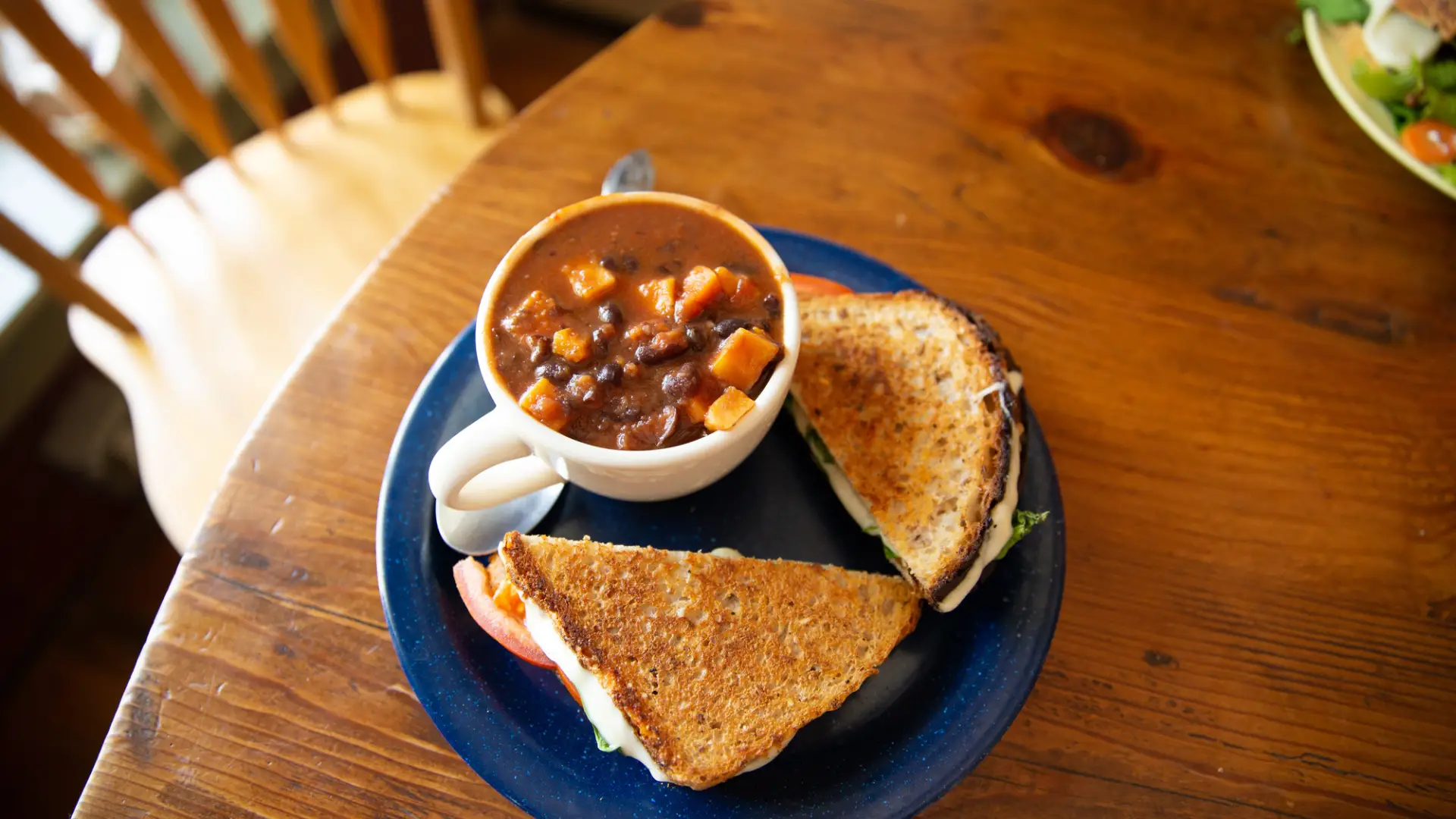 Plated sandwich and soup on a table.