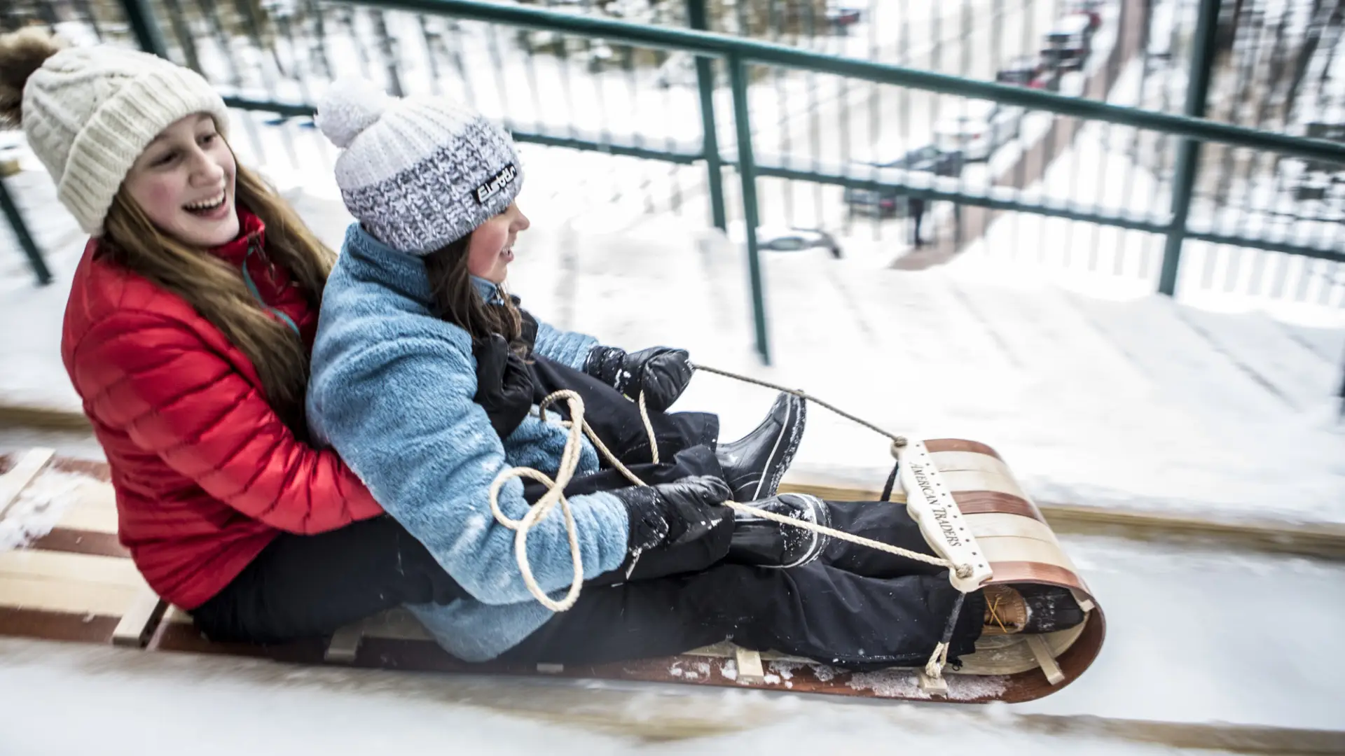 two girls on a toboggan slide down a 30 foot chute