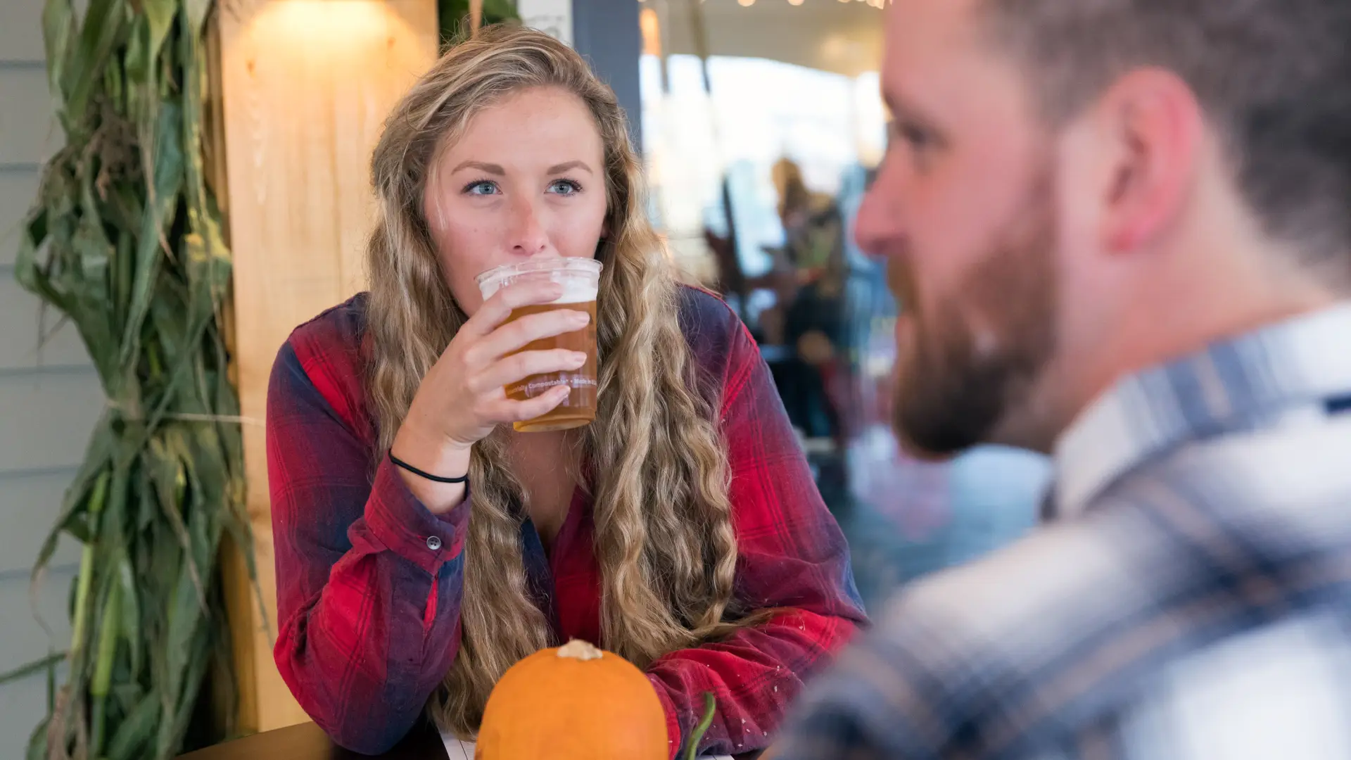 A young woman drinking a beer in Lake Placid in the fall.