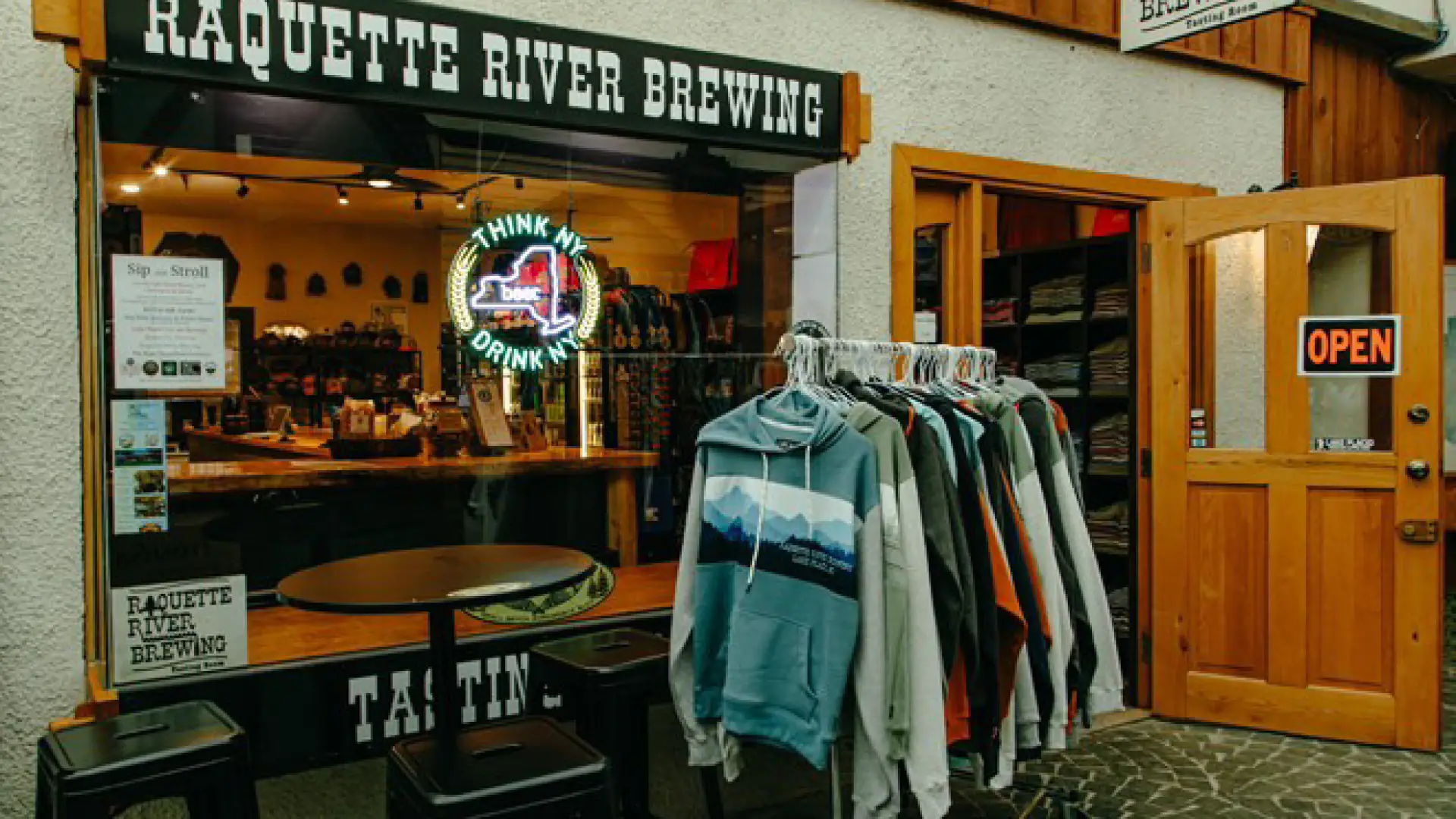 The exterior of the tap room with a rack of branded hoodies
