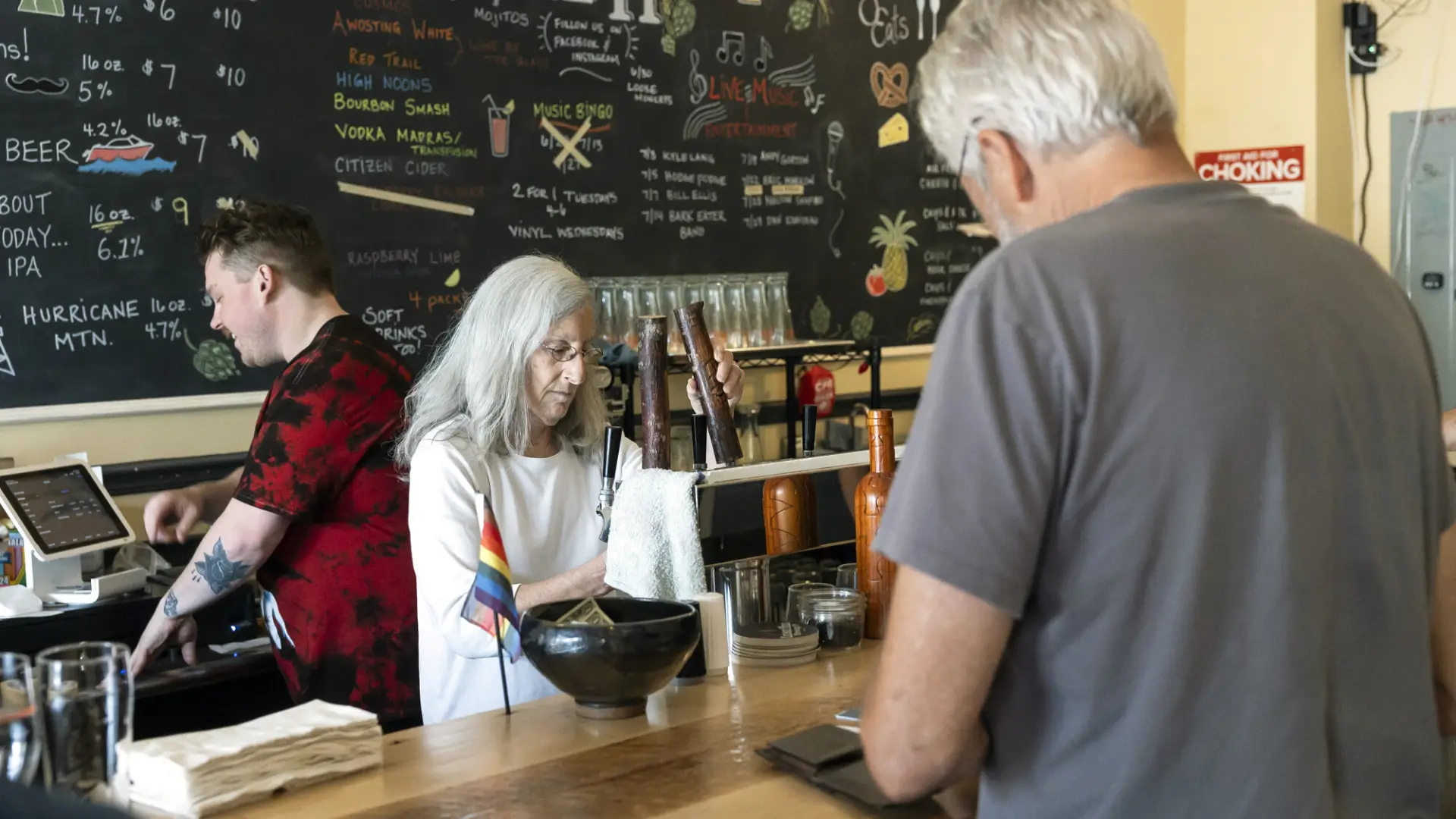 A man checks out at a bar during the day. 