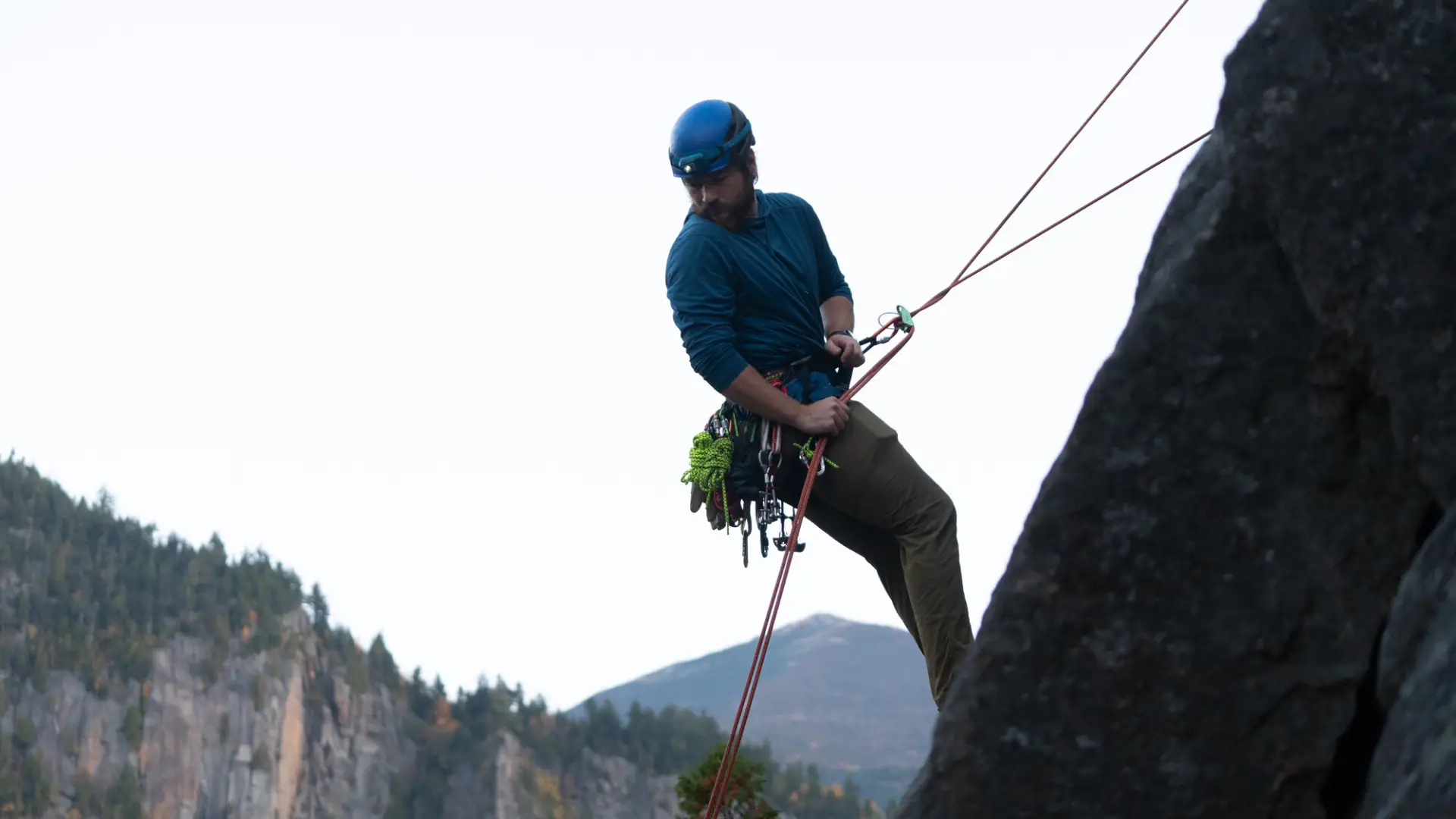 A climber rappelling down a cliff