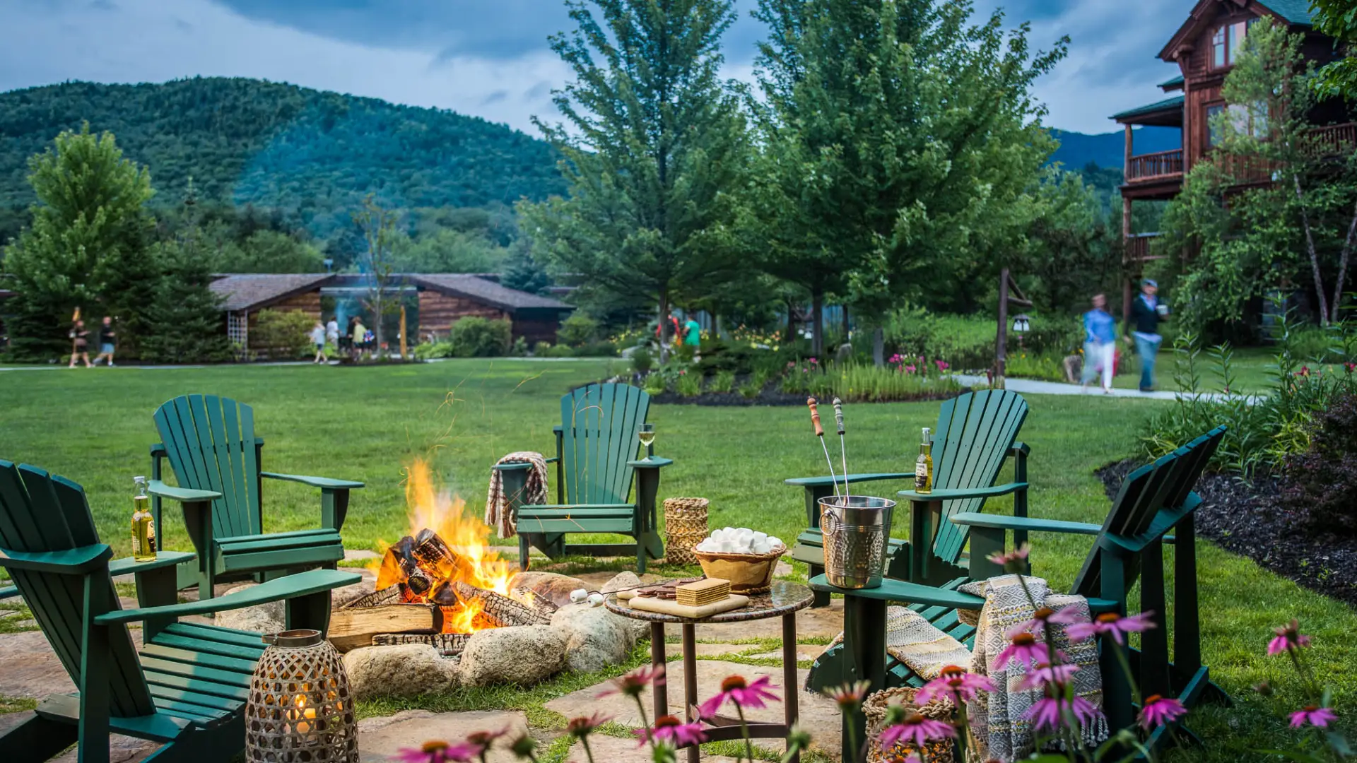 Adirondack chairs around an outdoor fire place.
