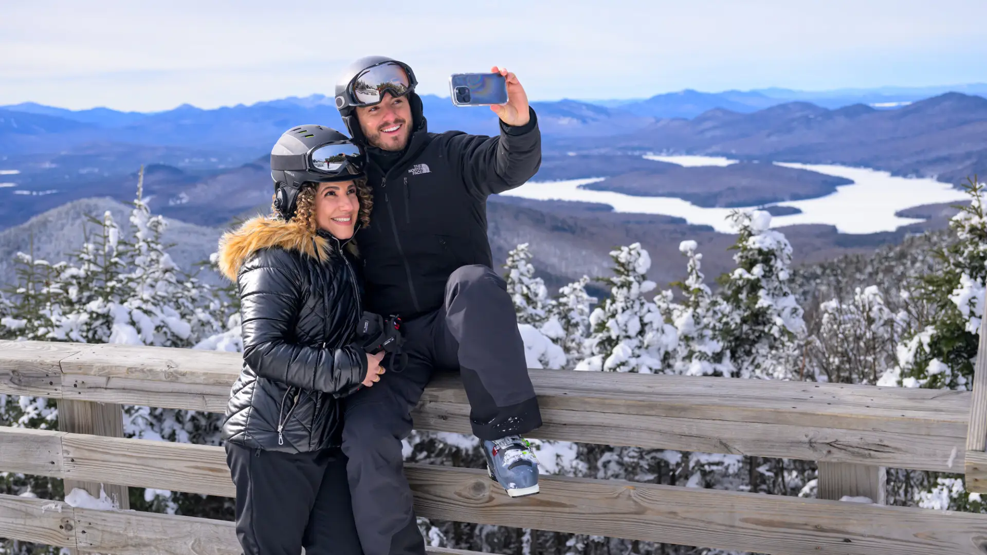 A man and woman take a selfie in ski gear.