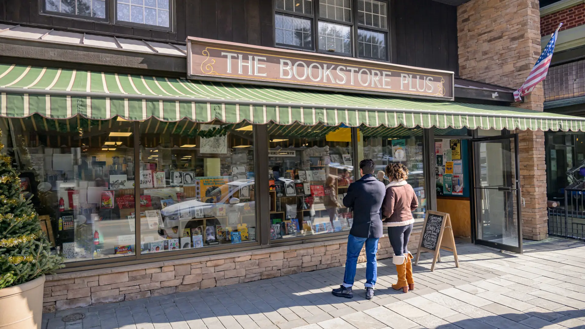 A man and woman window shop at a book store.