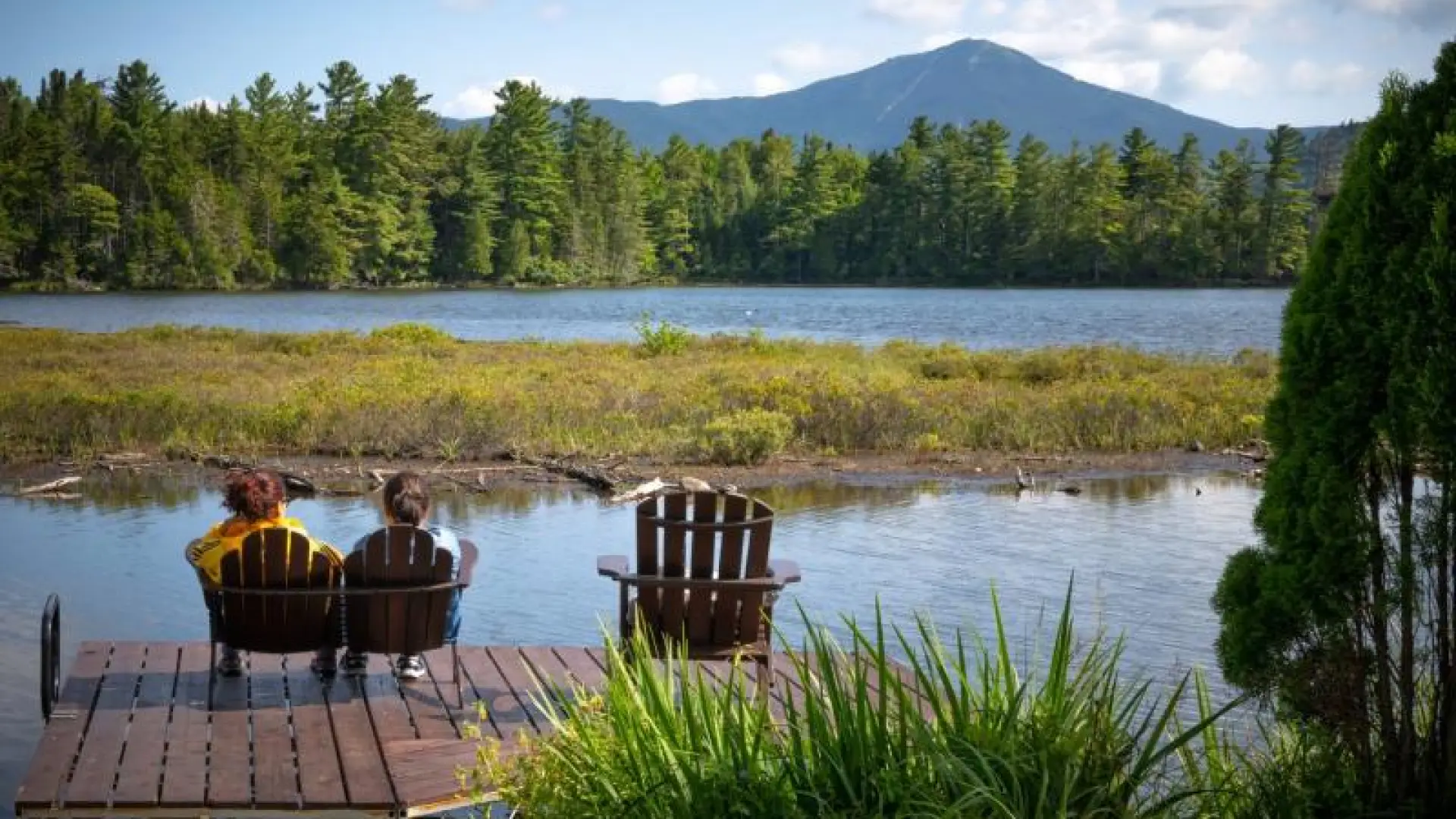 Two people sitting on a deck with views of the mountains