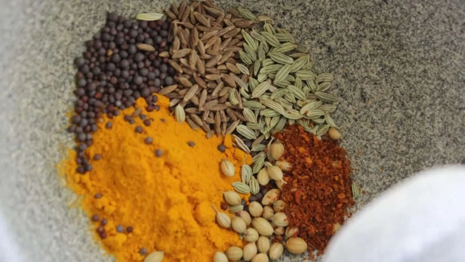 Herbs and spices of various colors in a bowl