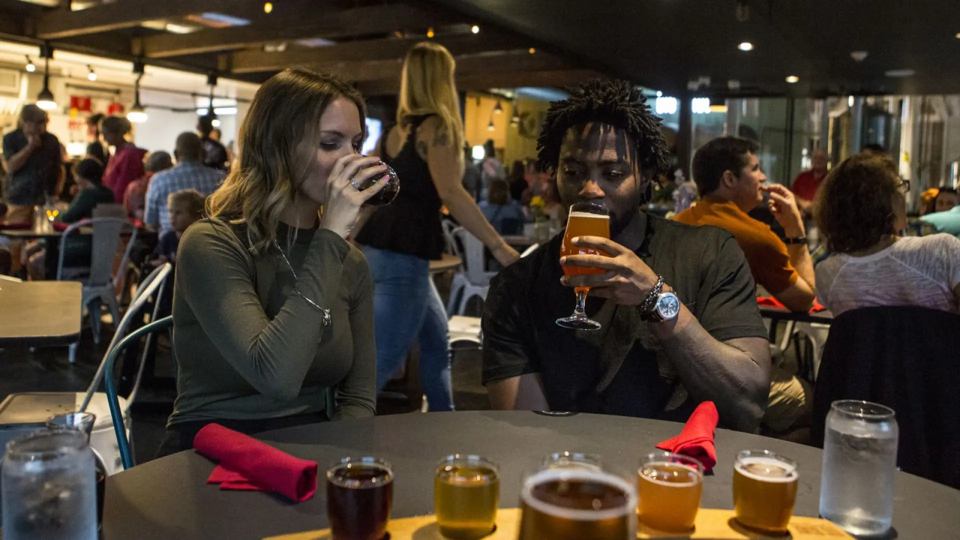 A man and woman sample beer in a busy Adirondack pub.