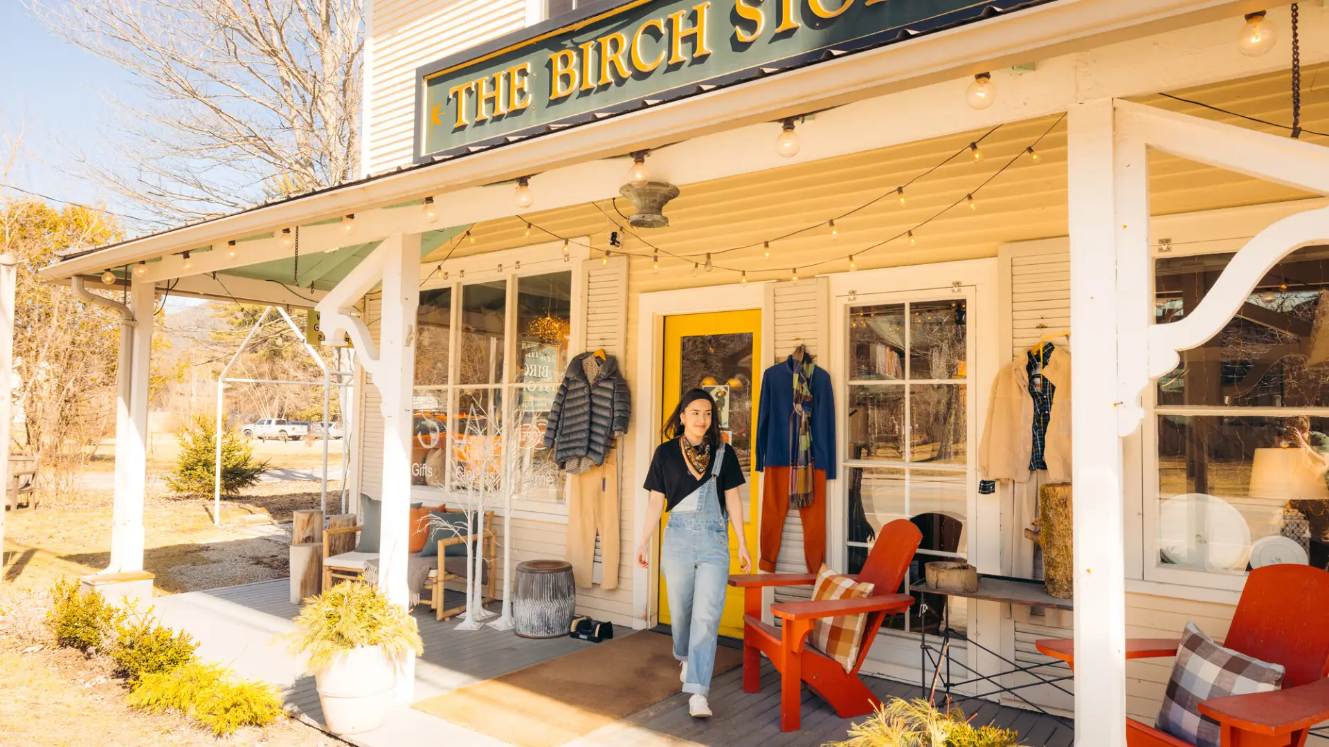 A woman walks out of a rustic shop. 