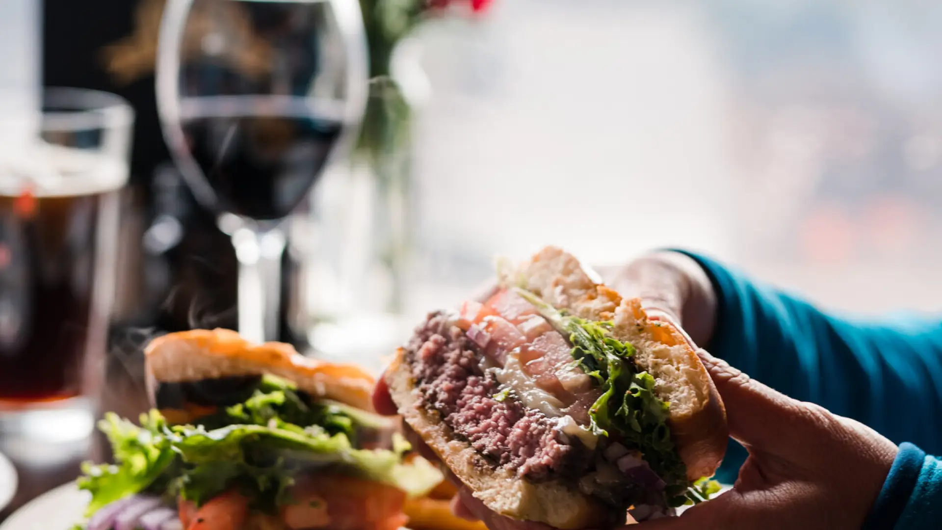 A juicy burger is held to take a bite.