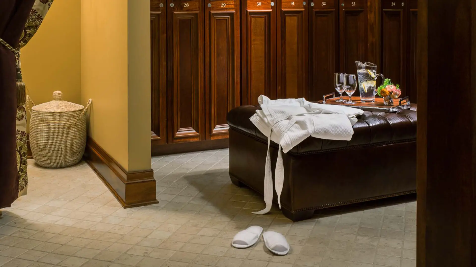 The ladies locker room with refreshments, a lush towel and robe, soft slippers and dark wooden lockers