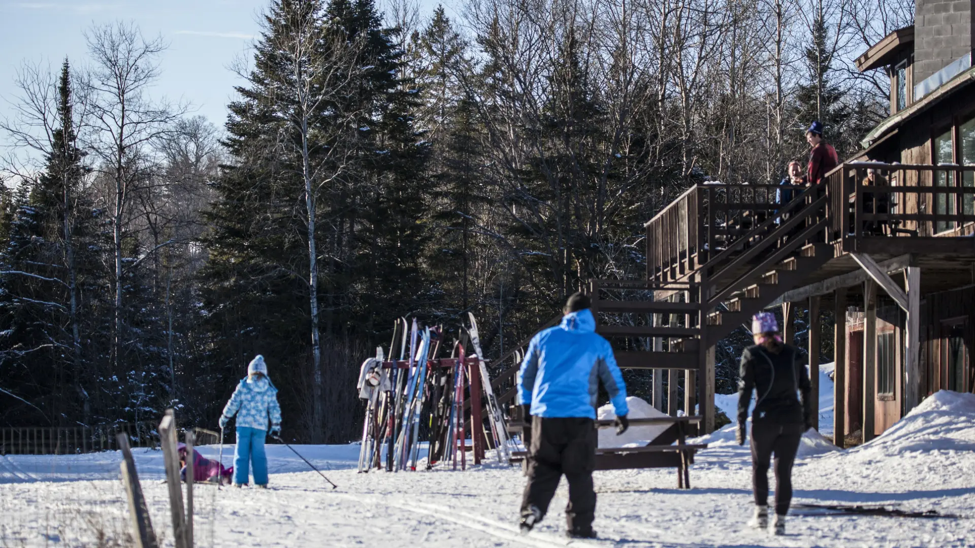 People outside the lodge at Cascade with skis on a rack