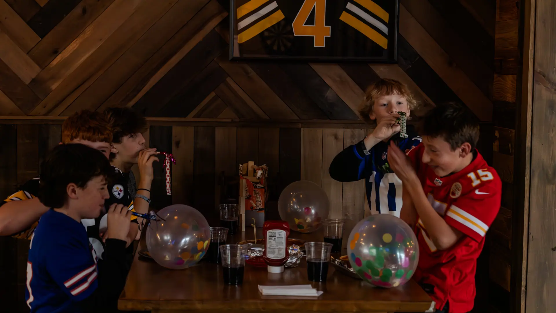 A bunch of boys at a birthday party with balloons filled with colorful confetti and noise makers.  Photo Credit to A. Kelly.