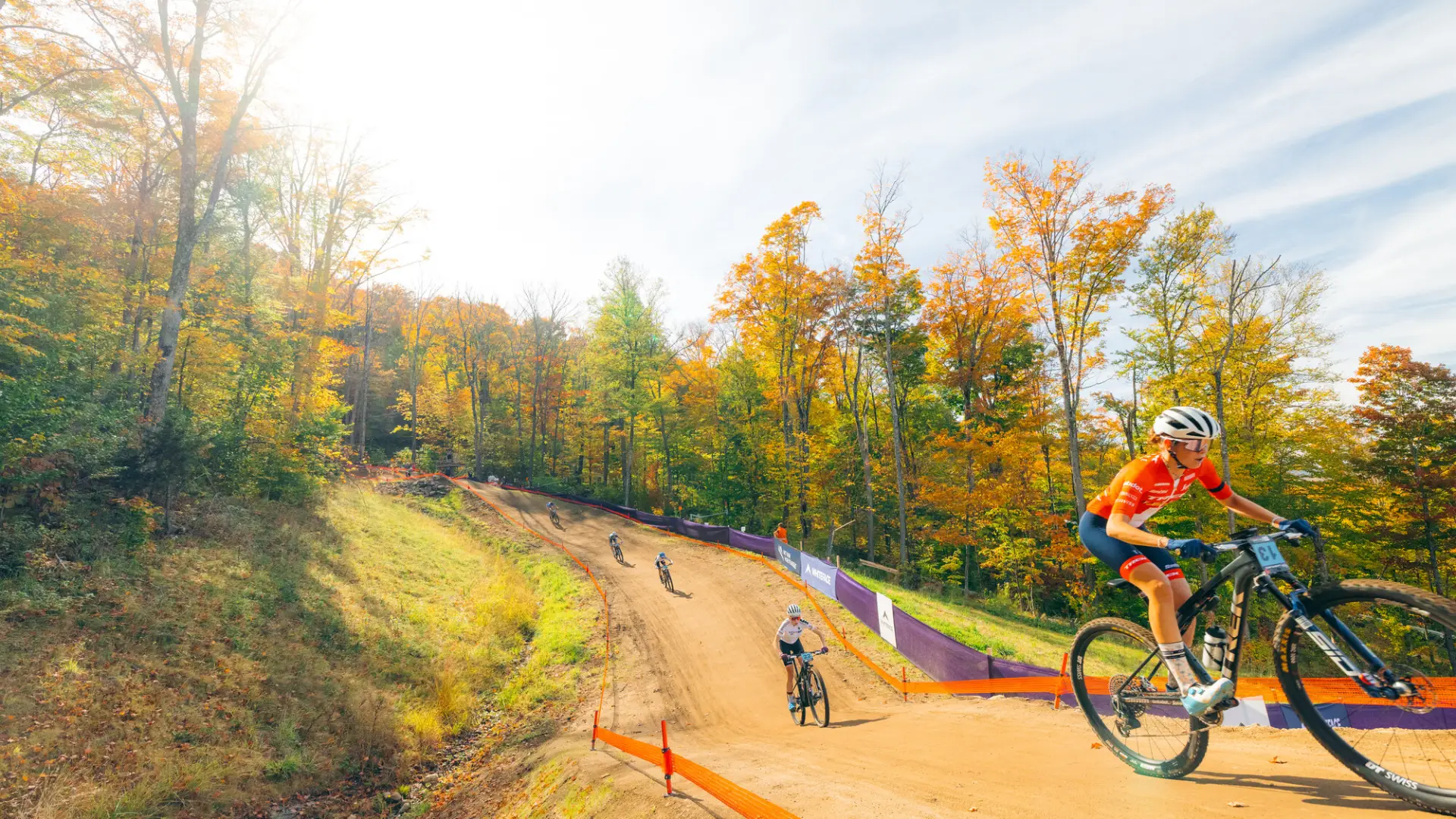 Female athletes bombing down a hilly section of the course.