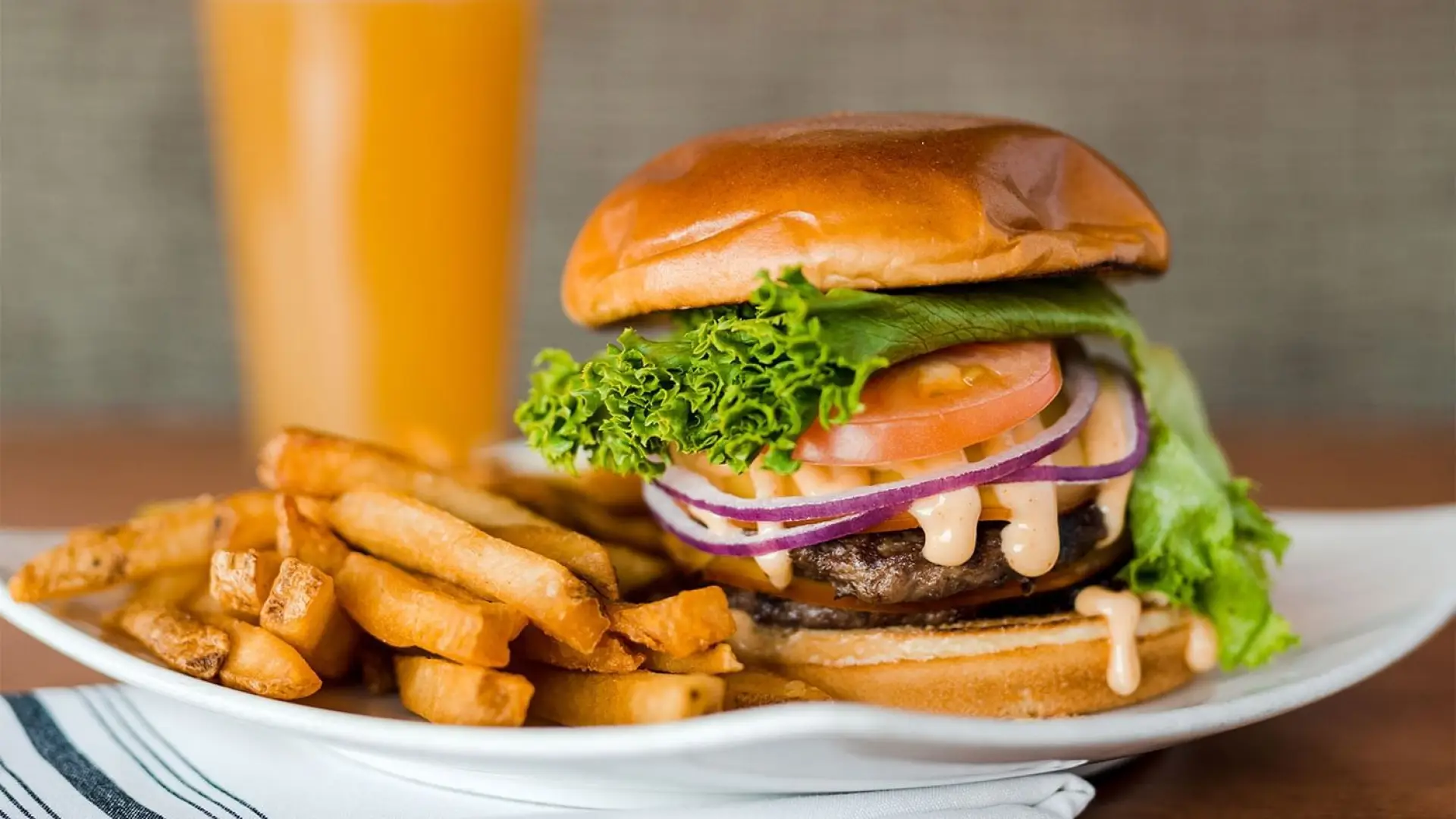 A juicy burger with all the fixin's, thick cut french fries and a luscious freshly poured beer.