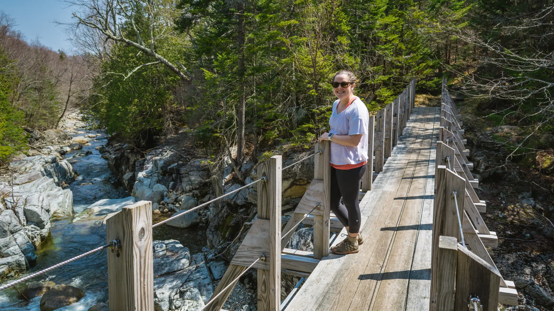 A hiker on the bridge across Johns Brook