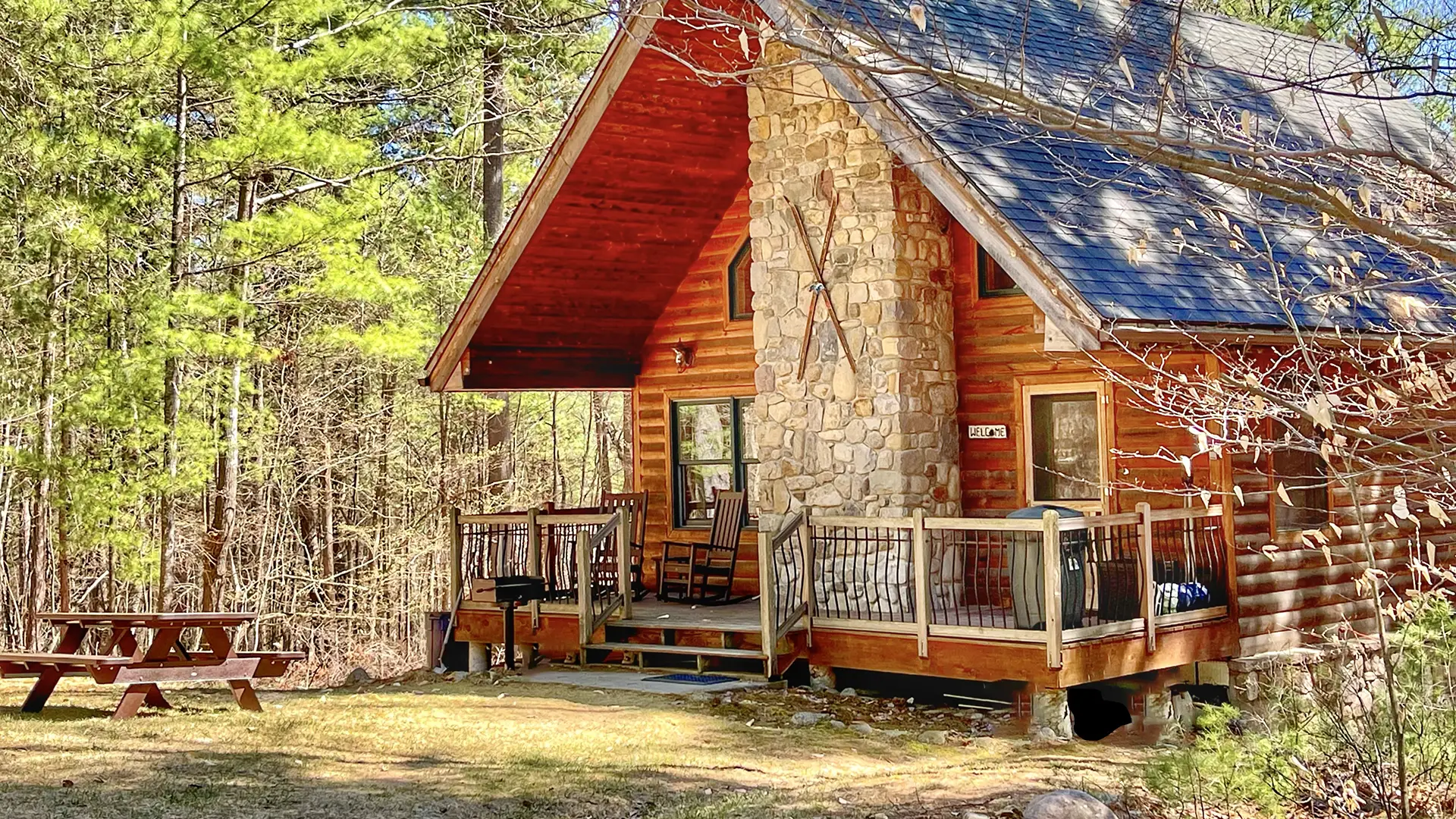 Cabin with stone fireplace, deck, and picnic table